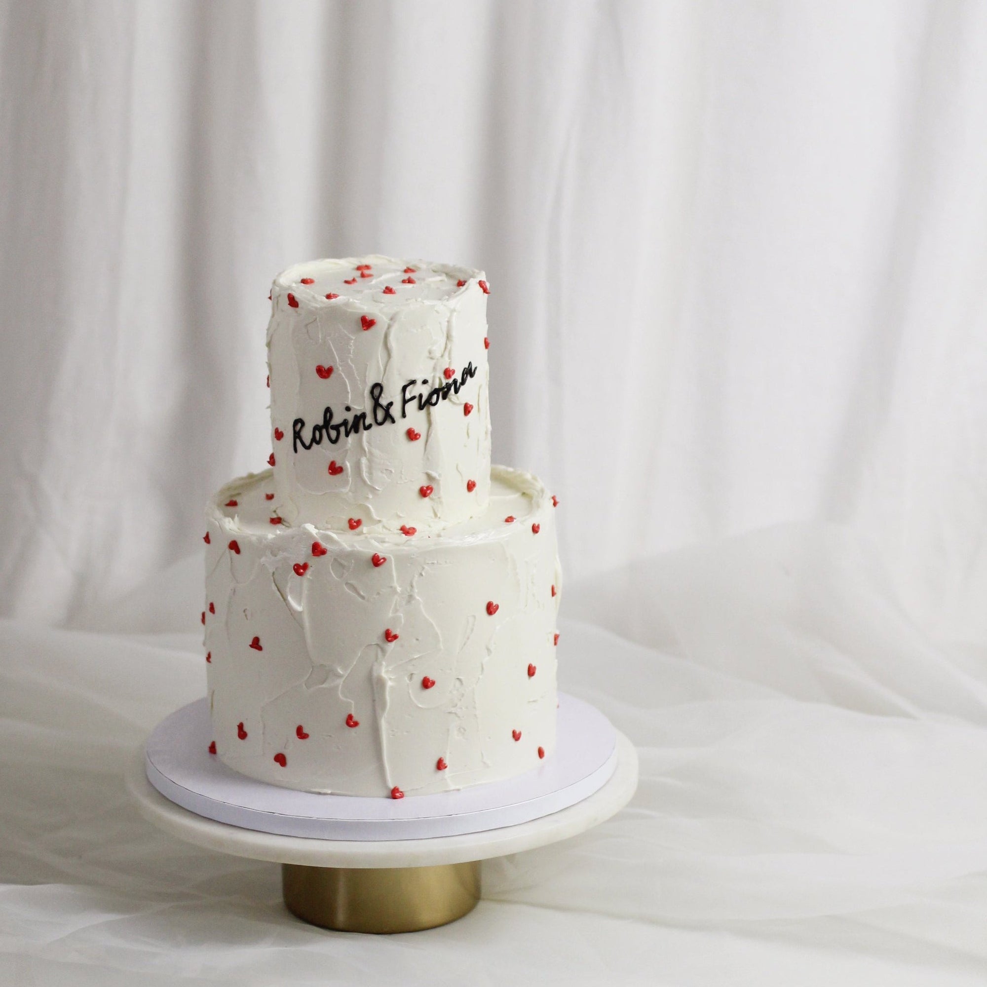 The classic wedding cake! Decorated white buttercream and handpainter red hearts. Personalized your cake with a cute message on top! Made in our Kreuzberg studio - delivered in Berlin!