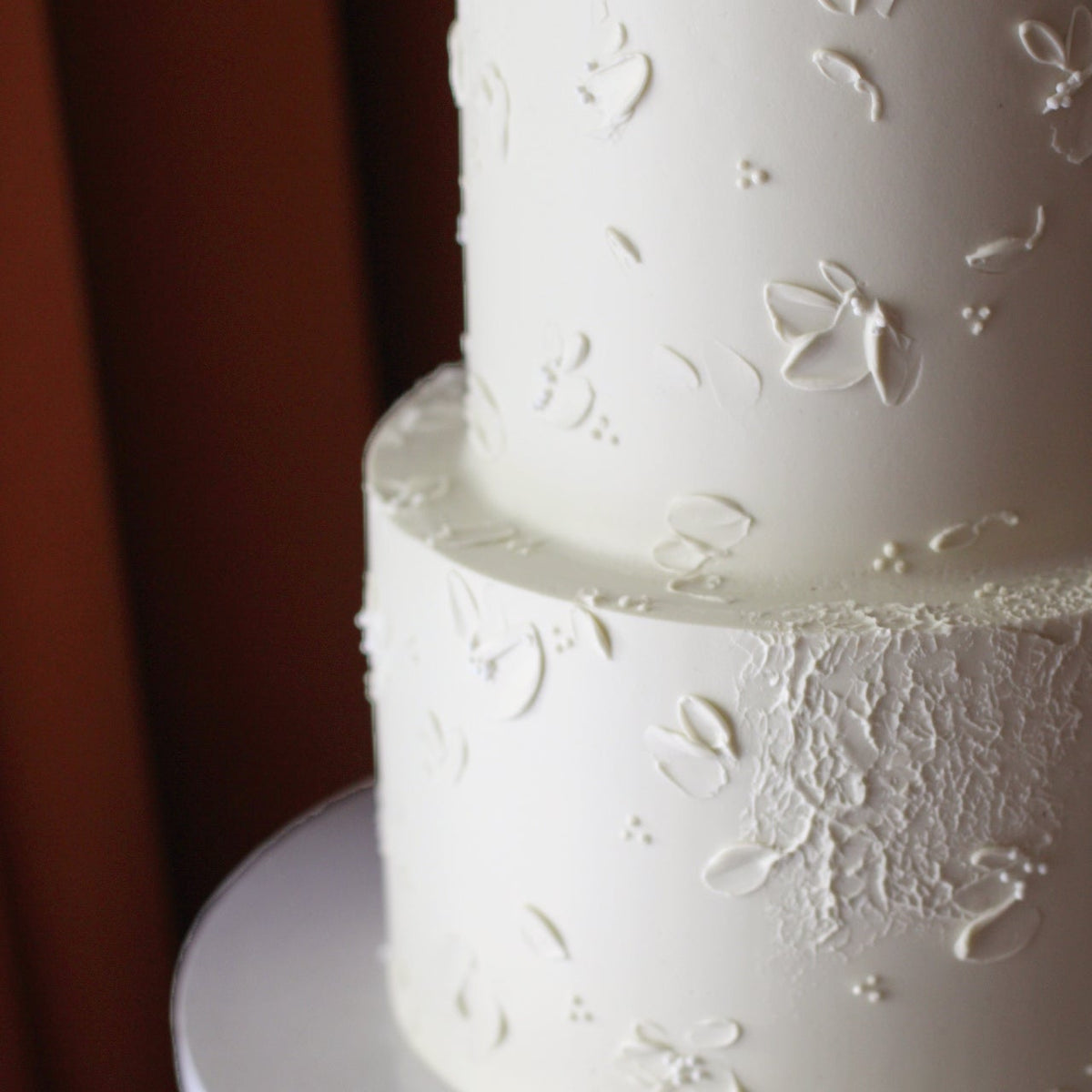 Close-up of the hand-painted white buttercream florals - a classic yet modern all white wedding cake