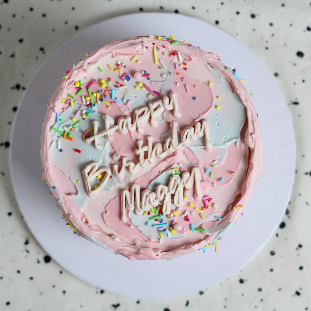 Our signature Birthday Cloud Cake with blue &amp; pink fluffy icing and a dash of sprinkles, with handwritting message on the cake