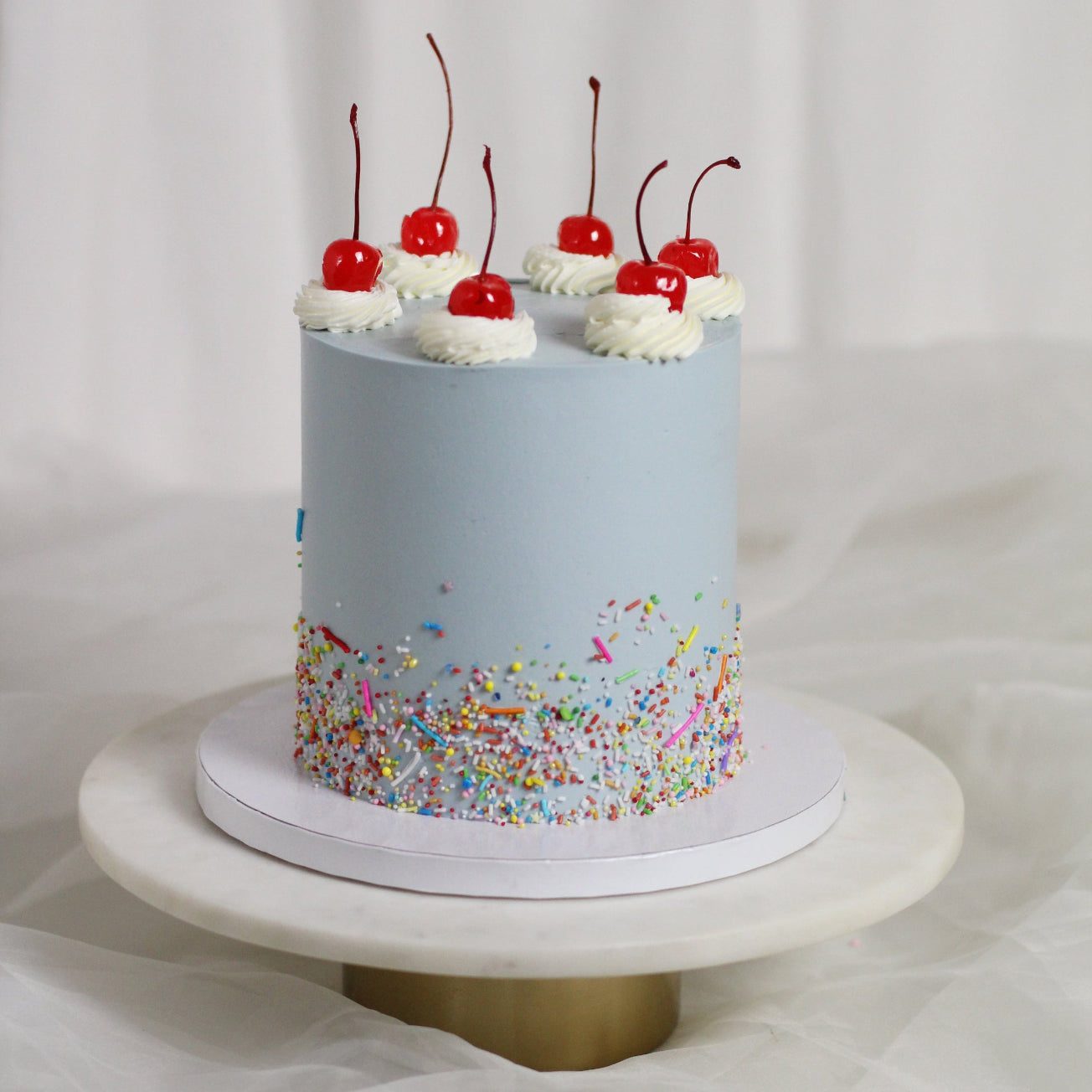 CHERRY BOMB - Every child´s dream birthday cake! Light blue icing, sprinkles and delicious red cherries on top!