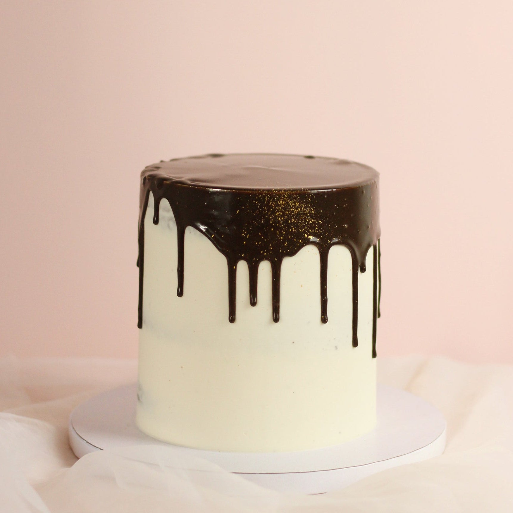 Smooth white cake and dark chocolate drips