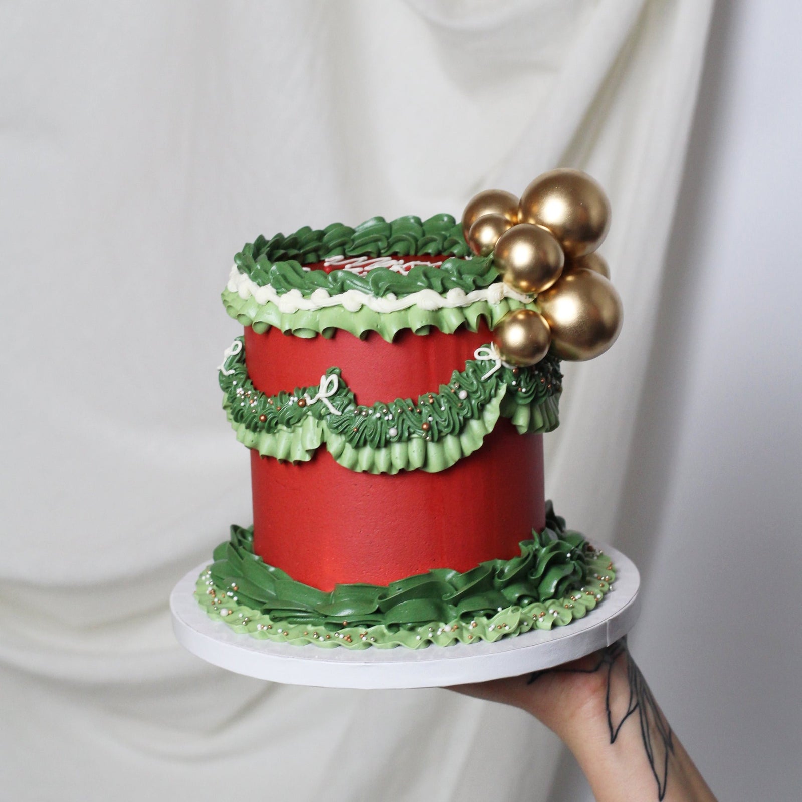 Christmas cake decorated with red and green frills and golden balls, perfect for holiday celebrations, festive dessert tables, and seasonal parties. Beautiful and festive holiday cake.
