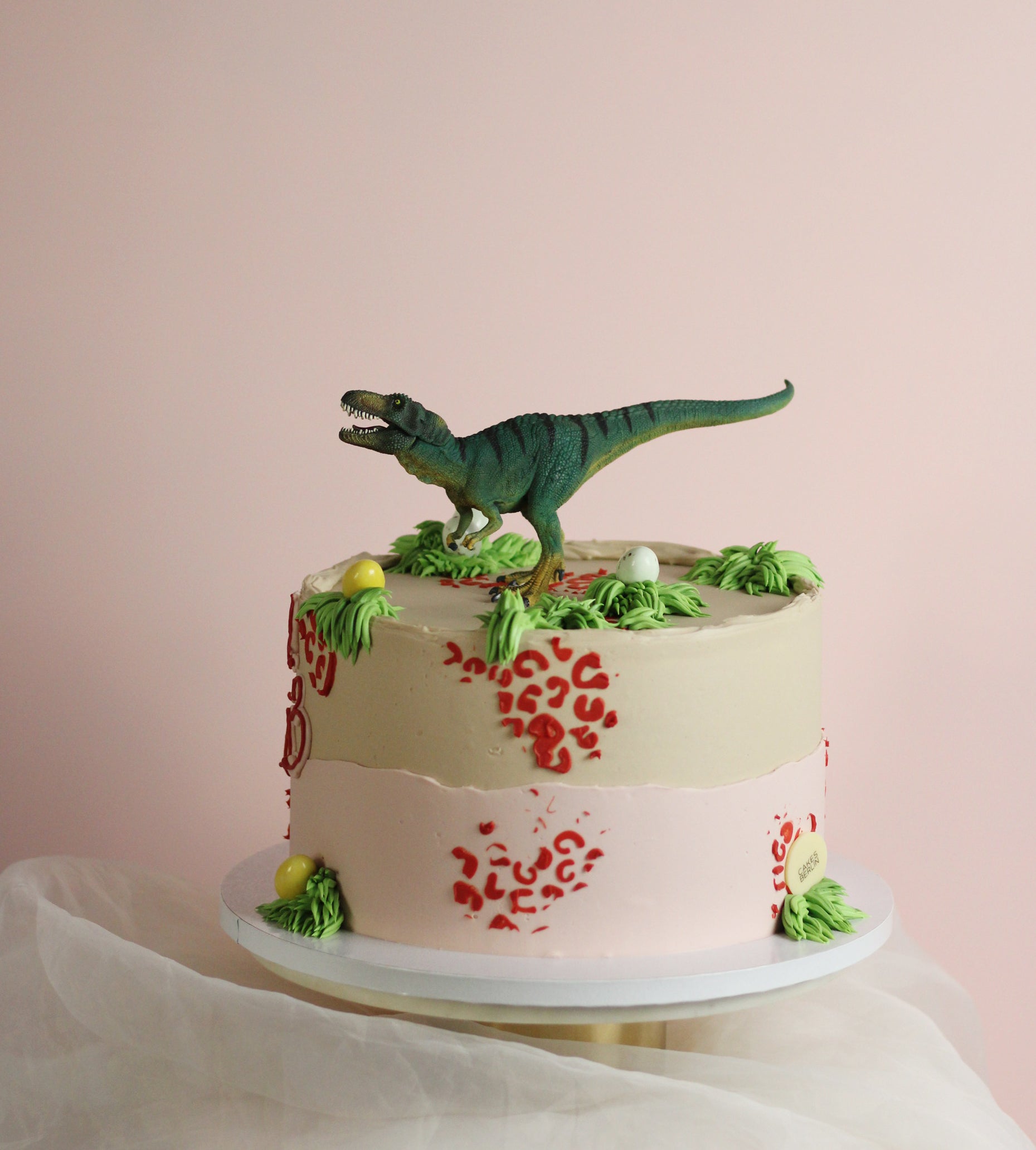 Dino cake in beige with red and green details