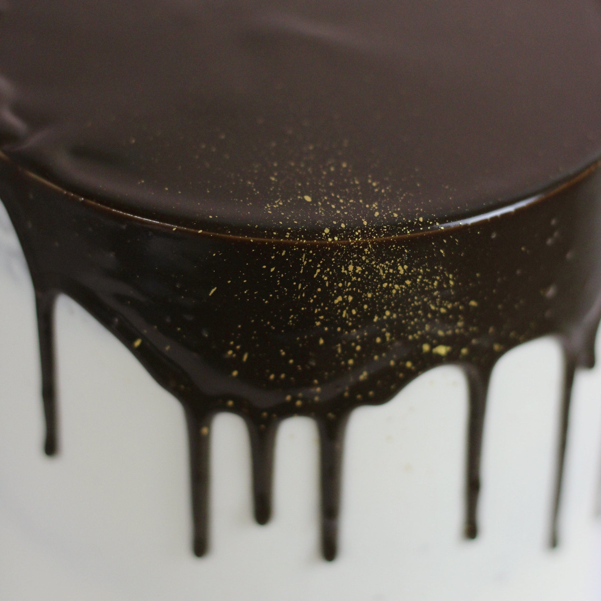 Smooth white cake and dark chocolate drips
