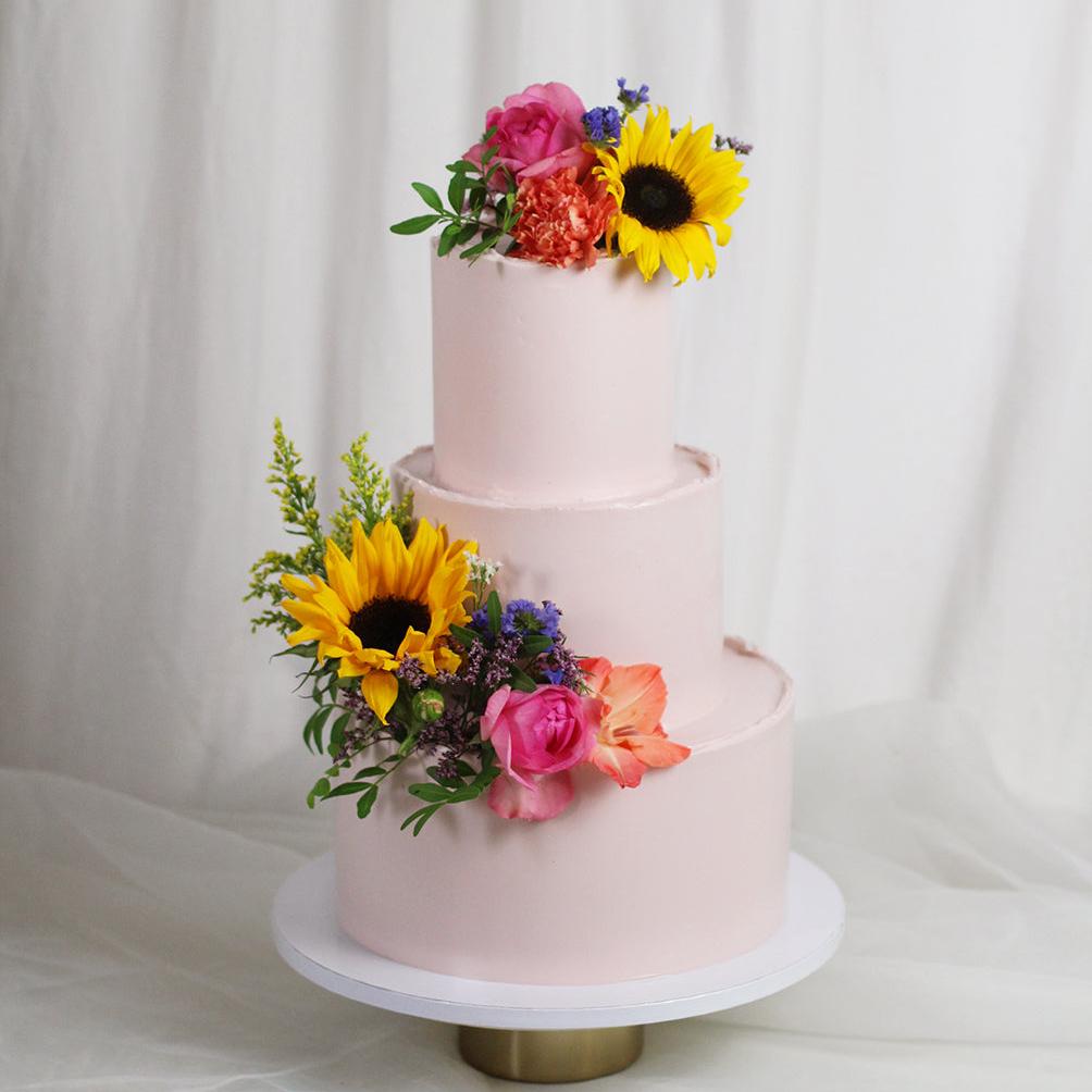 Rosé cake adorned with fresh flowers, ideal for colorful Summer wedding in Berlin wedding