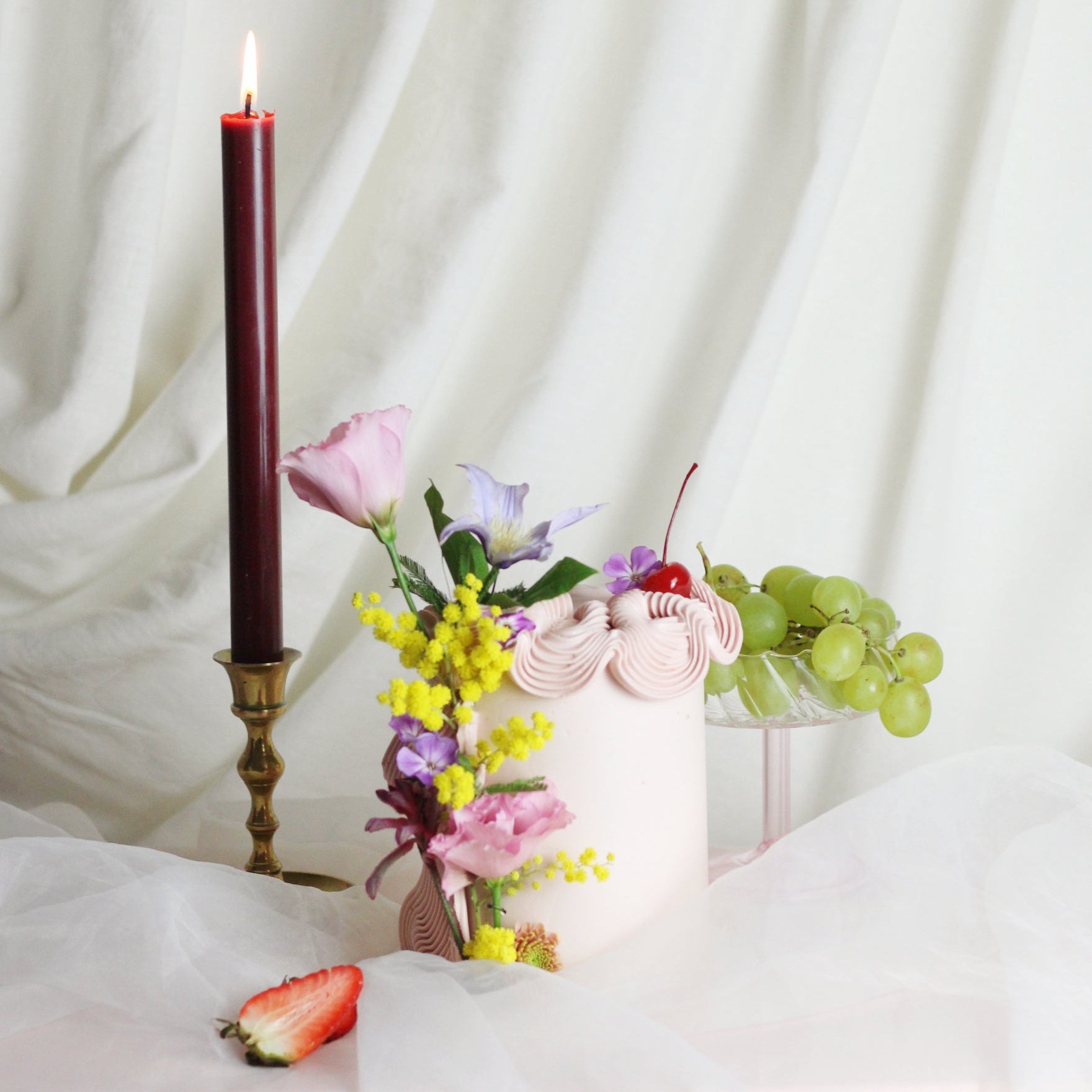 Light pink buttercream, maraschino cherries, and elegant decorative flowers, ideal for celebrating love.