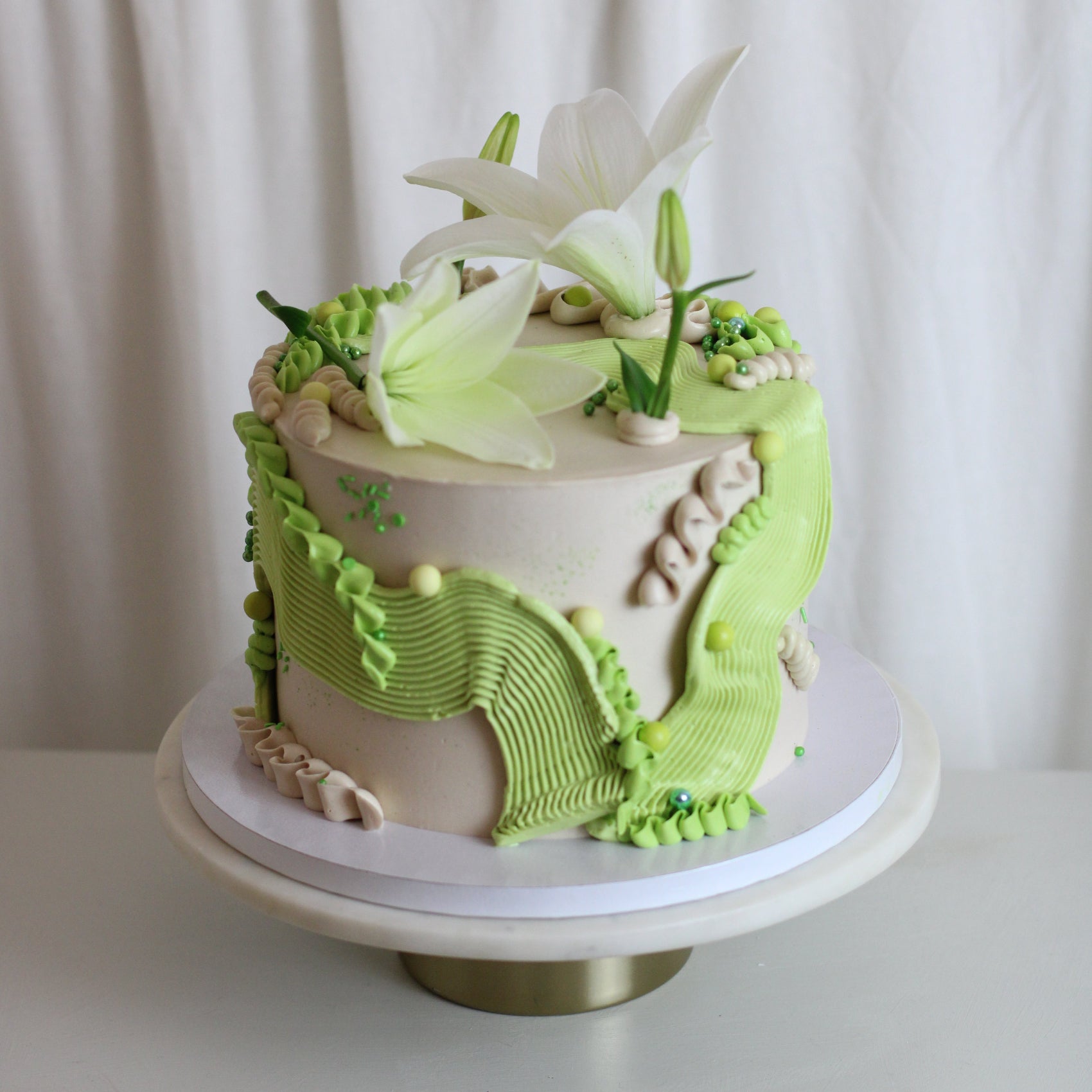 Fully custom frilly cake decorated with squiggly buttercream and fresh flowers.