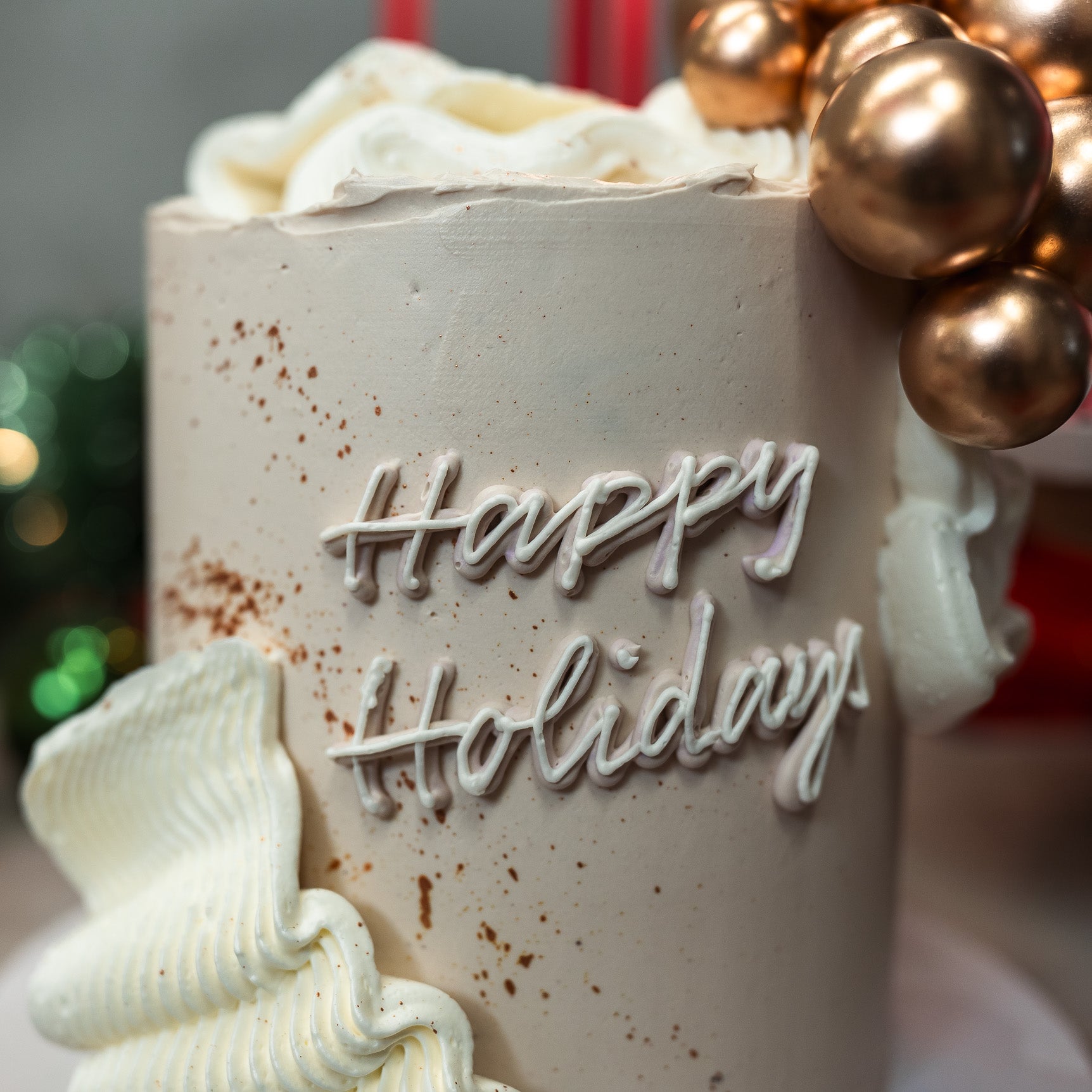 Details of Off-white festive Christmas cake with large buttercream frills and golden balls, perfect for holiday celebrations, Christmas dessert tables, and seasonal parties. Elegant and festive holiday cake.
