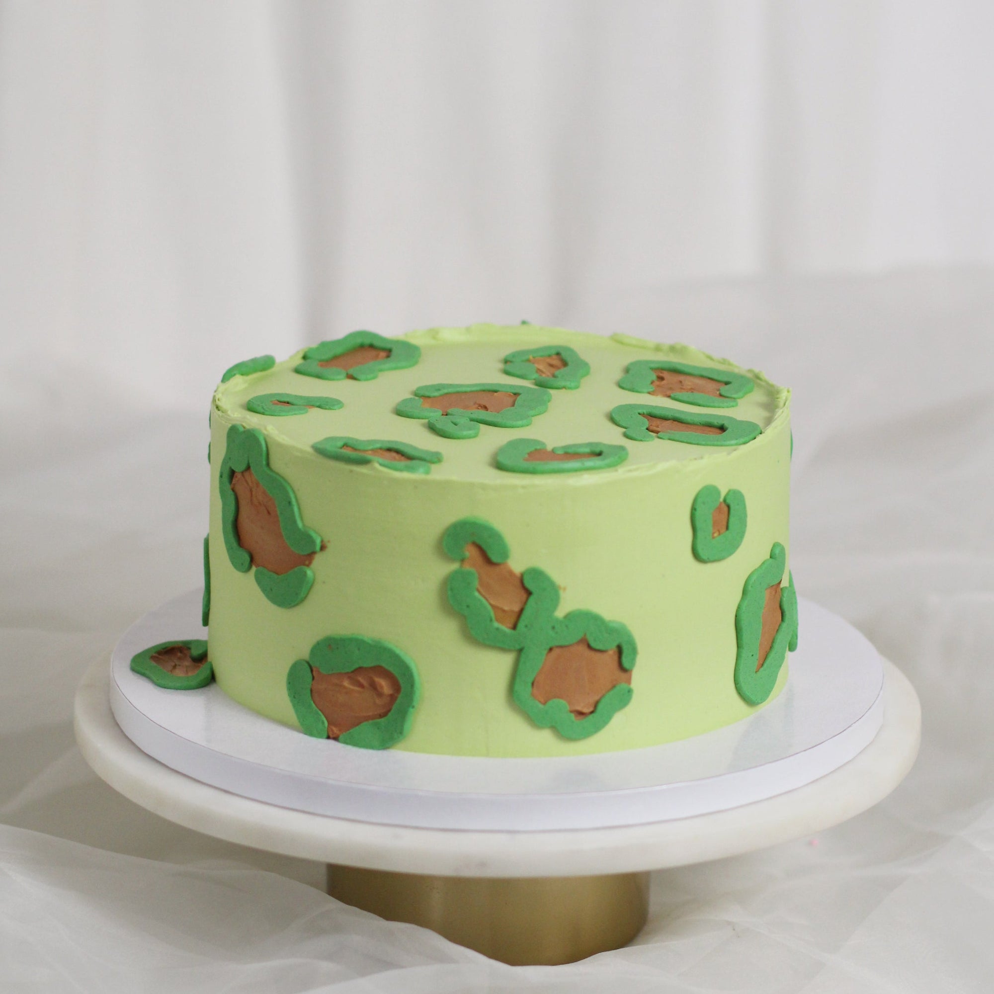 Light greencake decorated with leopard print buttercream