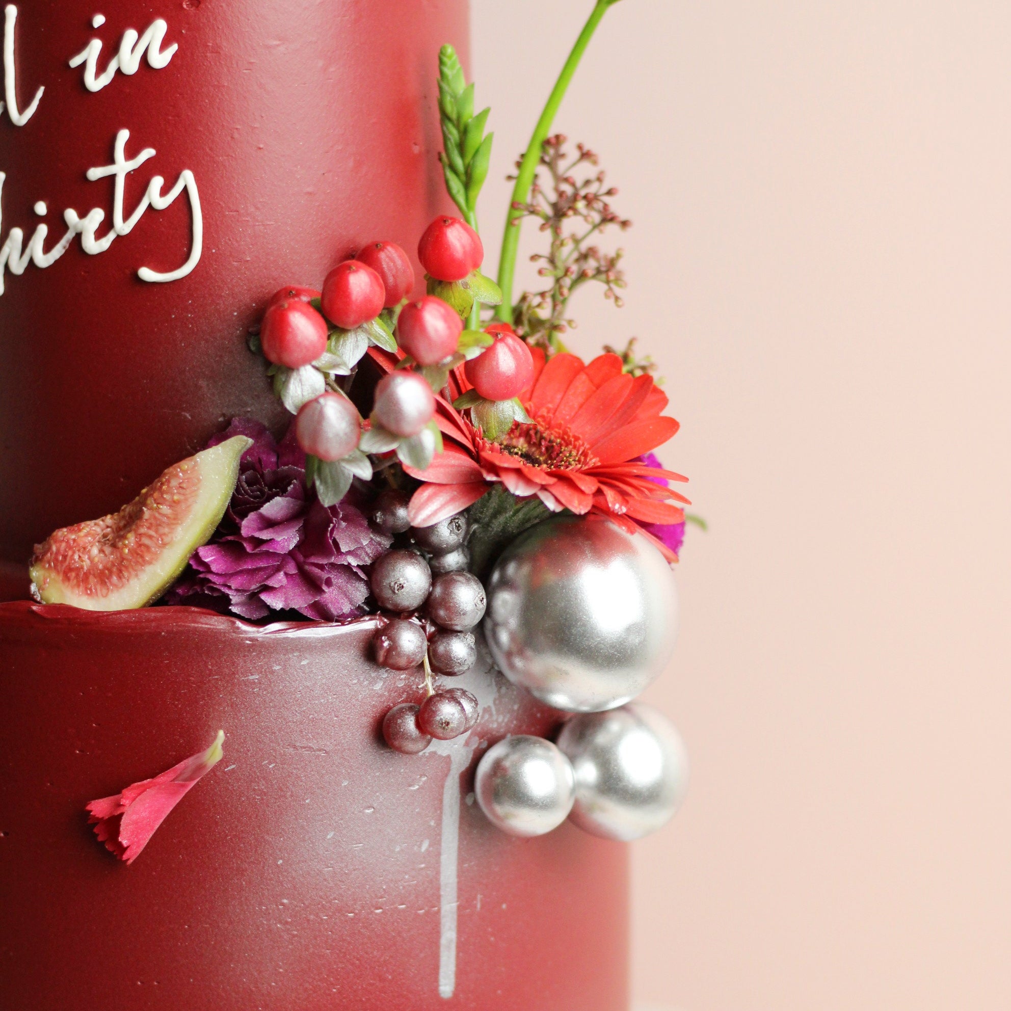 Wine-red celebration cake with figs, berries, and fresh florals. Elegant two-tier design for birthdays and special events.