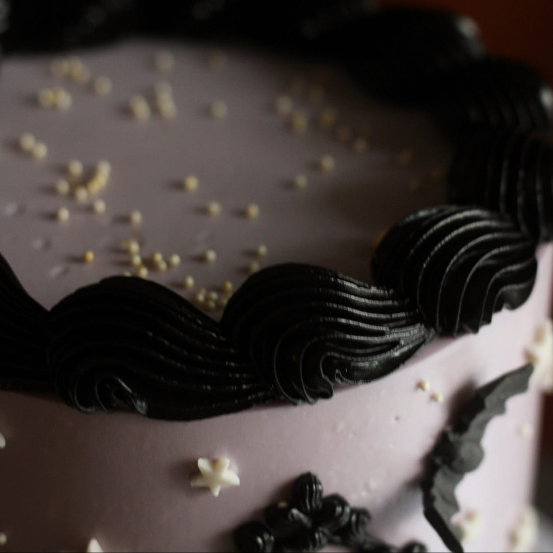 A delicious, creepy vintage cake decorated with night sky details on a spiderweb stand. Join our halloween cake decorating workshop in Berlin and learn to make that instagrammable cake yourself. A super fun activity for friends! Tolles To-Do in Berlin für alle Cake Lovers. Perfekt für deine nächste Halloween Party!