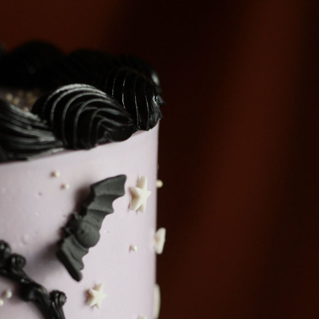 A delicious, creepy vintage cake decorated with night sky details on a spiderweb stand. Join our halloween cake decorating workshop in Berlin and learn to make that instagrammable cake yourself. A super fun activity for friends! Tolles To-Do in Berlin für alle Cake Lovers. Perfekt für deine nächste Halloween Party!