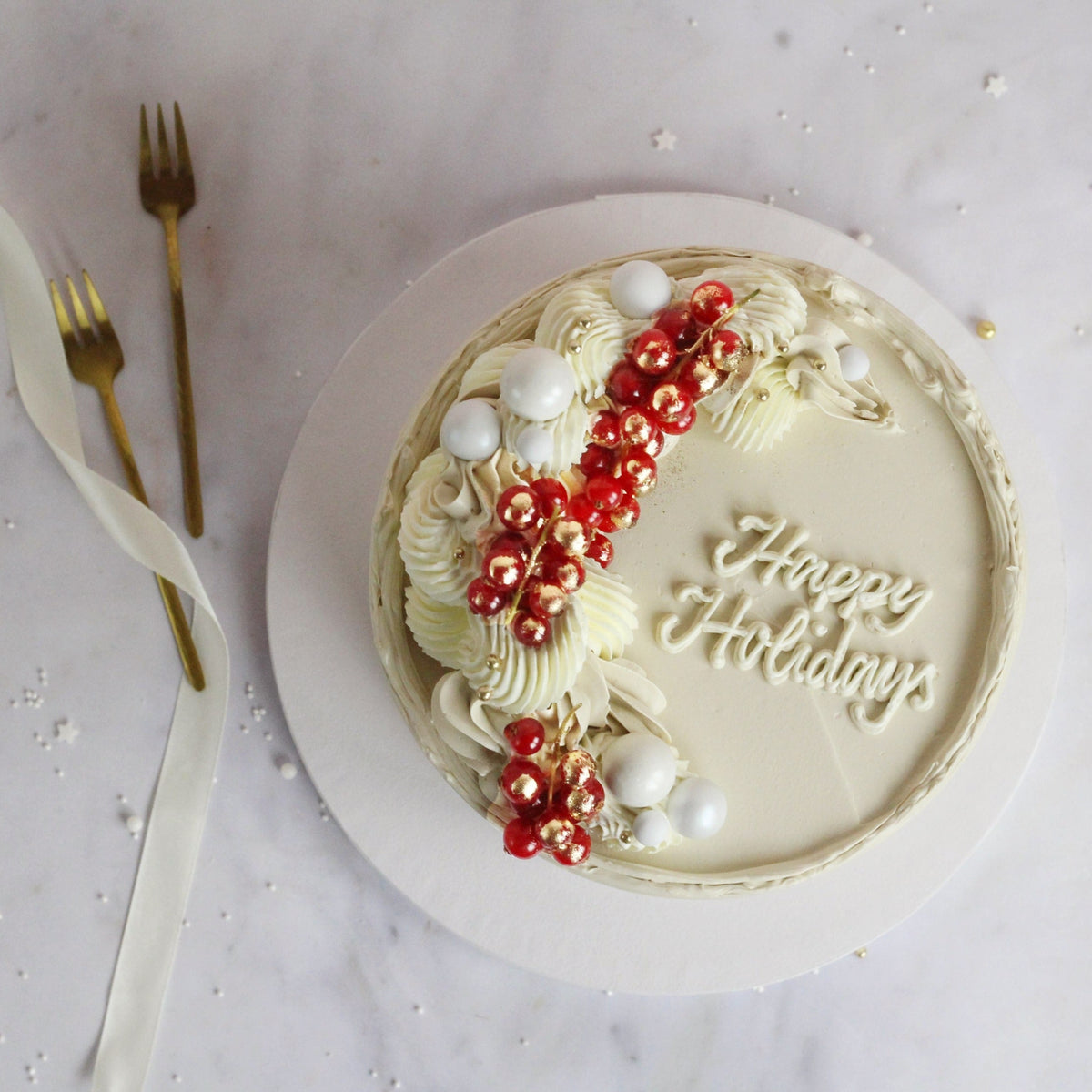Festive All-white cake decorated with fresh cranberries and gold hand-painted gold details, perfect for elegant celebrations, festive dessert tables, and special occasions
