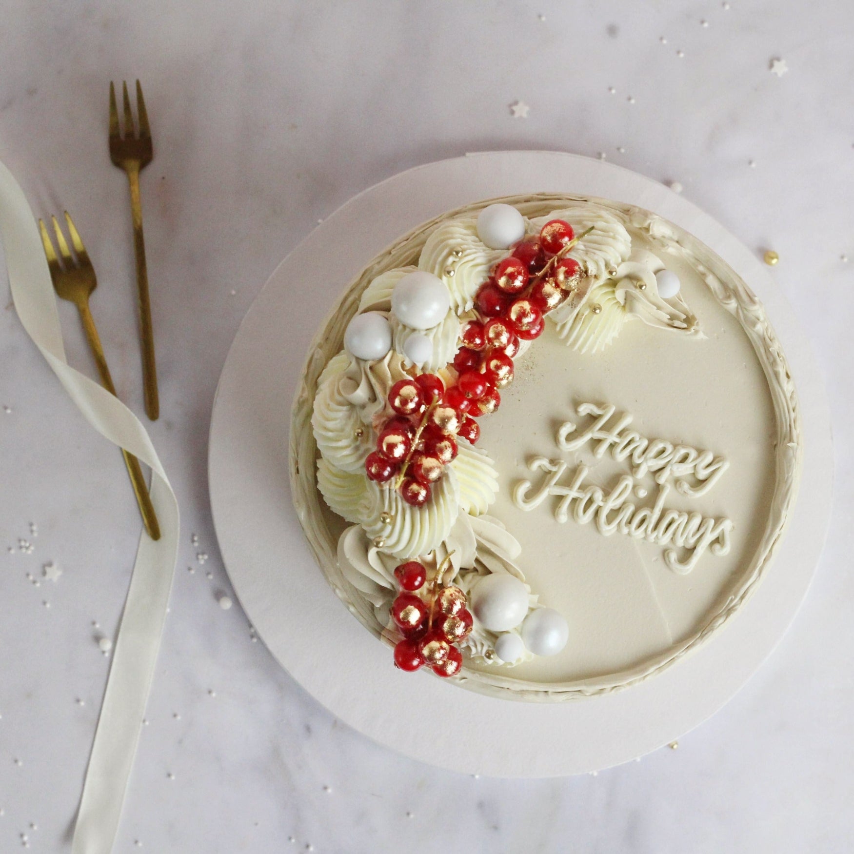 Festive All-white cake decorated with fresh cranberries and gold hand-painted gold details, perfect for elegant celebrations, festive dessert tables, and special occasions