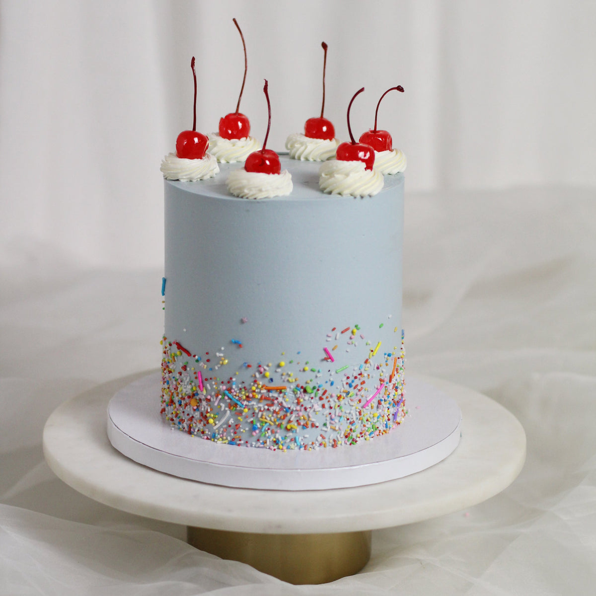 CHERRY BOMB - Light blue icing, sprinkle-filled bottom and delicious cherries on top!