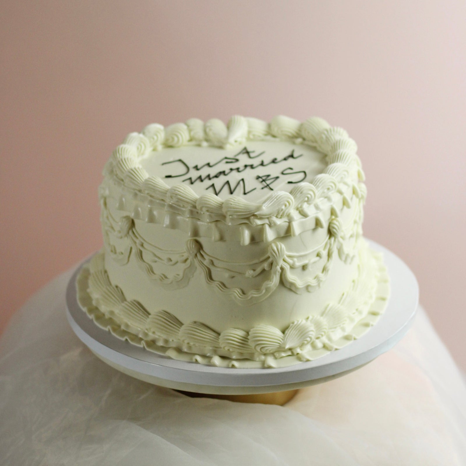 All-white heart-shaped cake with message on top