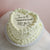 All-white heart-shaped cake with message on top.