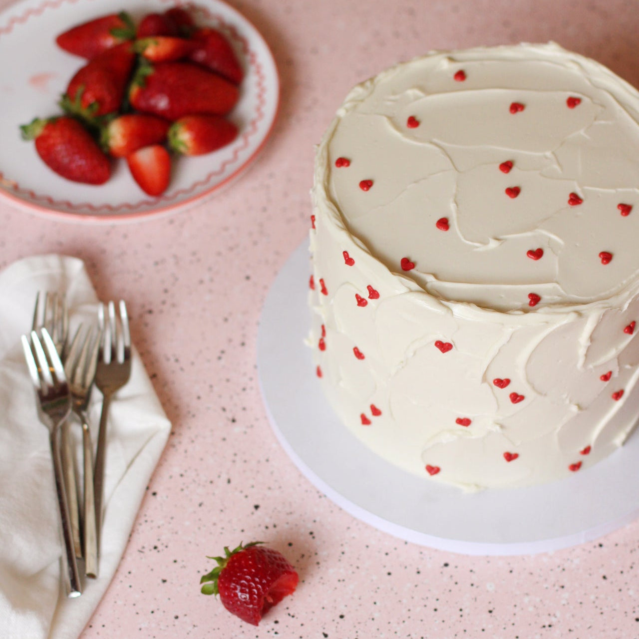White textured buttercream cake with  red hearts all around. Best paired with fresh strawberries:) 