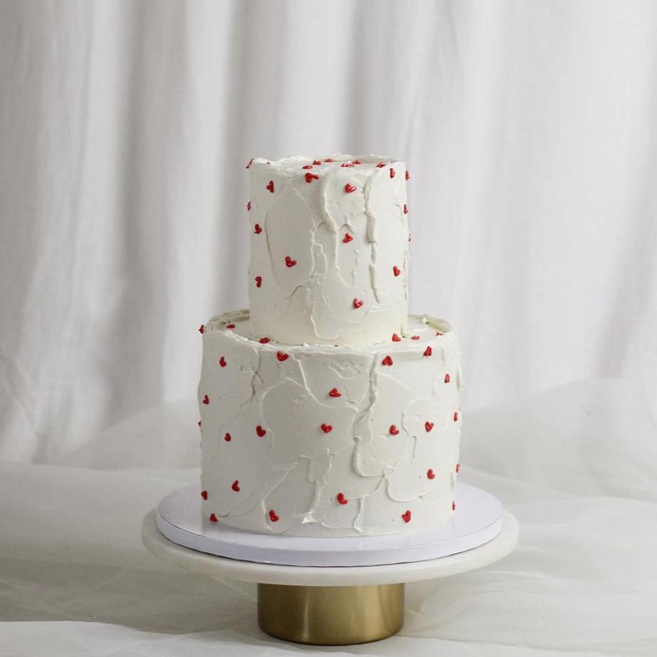 2-tier 25-30 serving. White textured cake base with hand piped red buttercream hearts