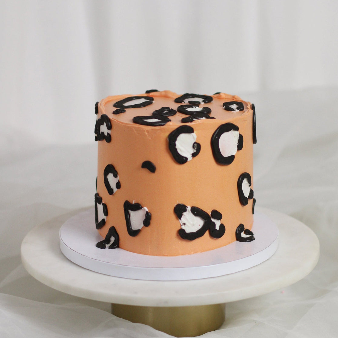 Orange cake decorated with leopard print buttercream