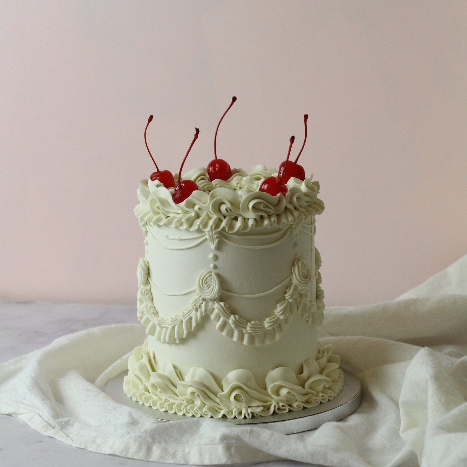 Single-tier vintage cake with red cherries