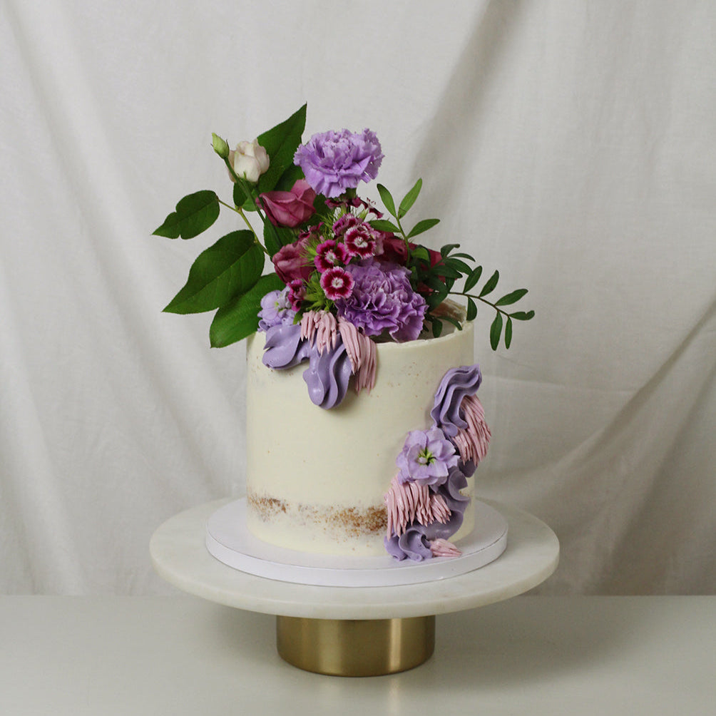 Sophie cake - purpule florals and fresh greens on a semi-naked cake