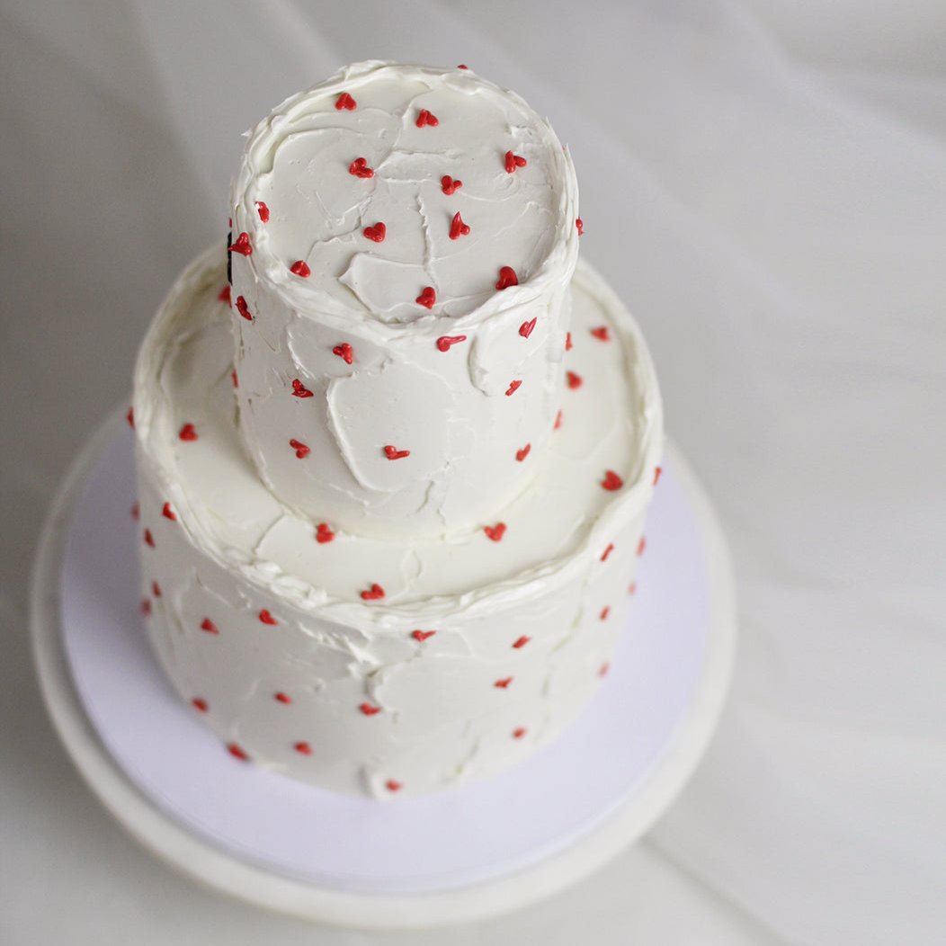 The classic wedding cake! Decorated white buttercream and handpainter red hearts. Personalized your cake with a cute message on top! Made in our Kreuzberg studio - delivered in Berlin!