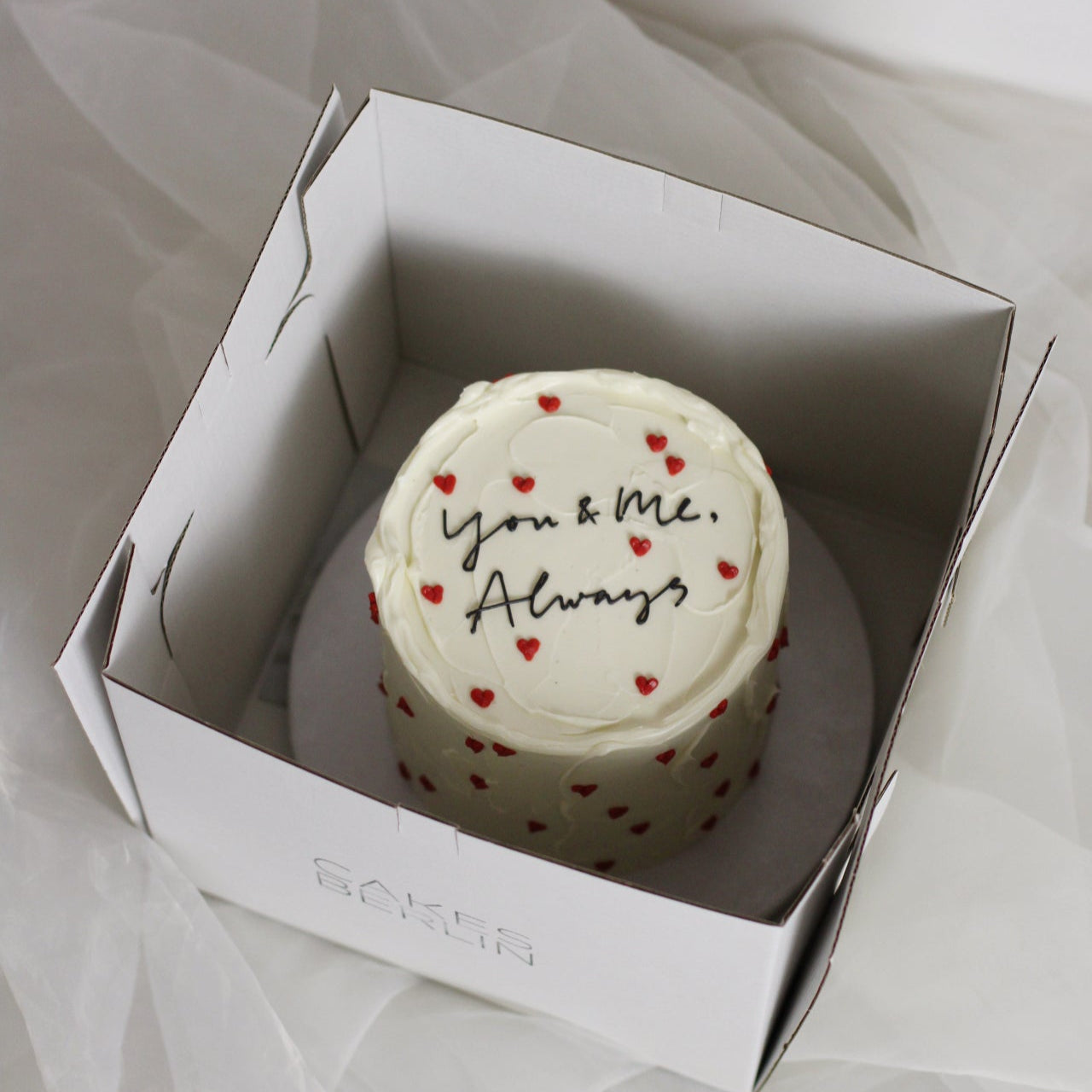 The classic anniversarry/ wedding cake! Decorated white buttercream and handpainter red hearts. Personalized your cake with a cute message on top! Made in our Kreuzberg studio - delivered in Berlin!