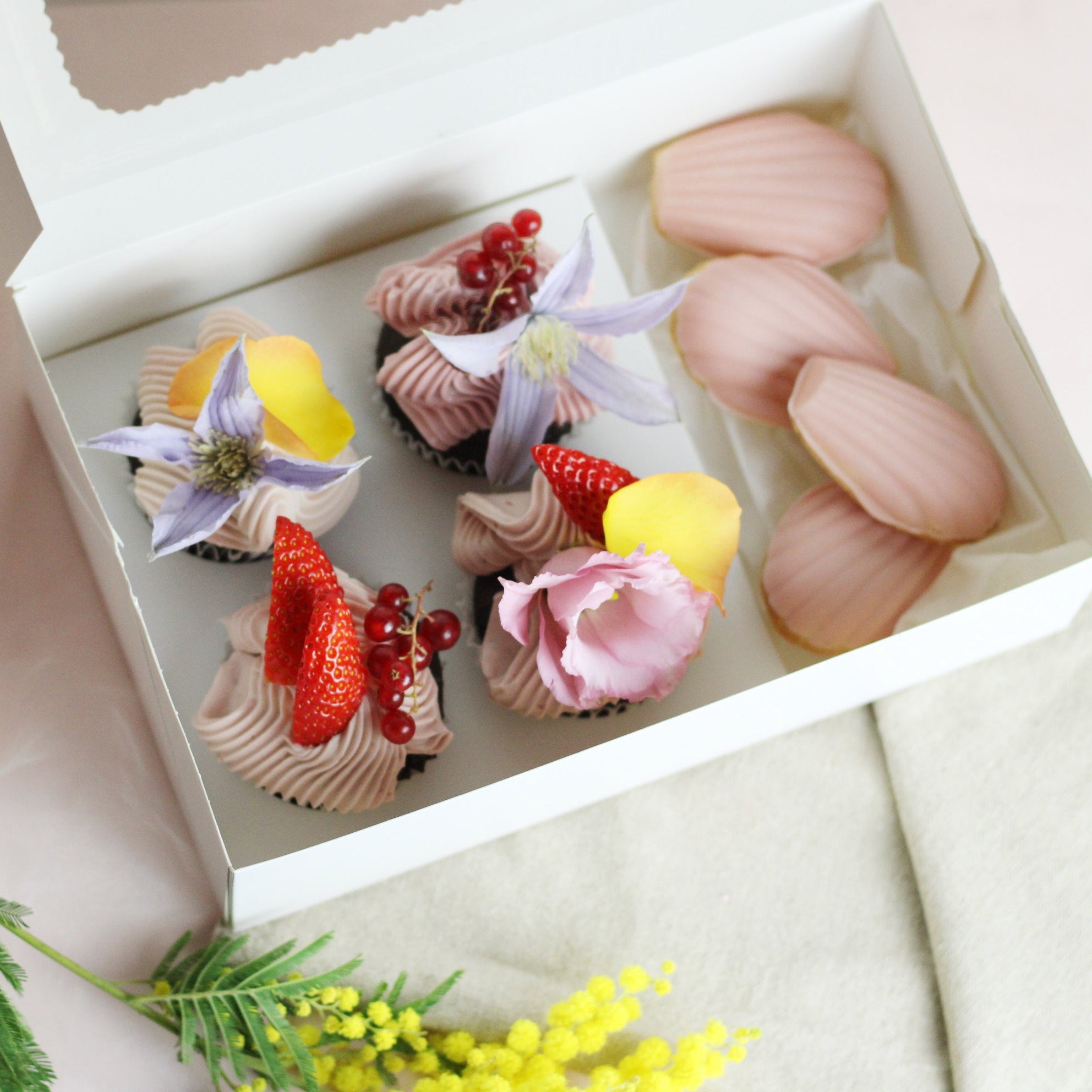 Valentine’s Special Box featuring fluffy cupcakes with pink buttercream, fresh berries, decorative flowers, and buttery madeleines. Perfect for celebrating love.