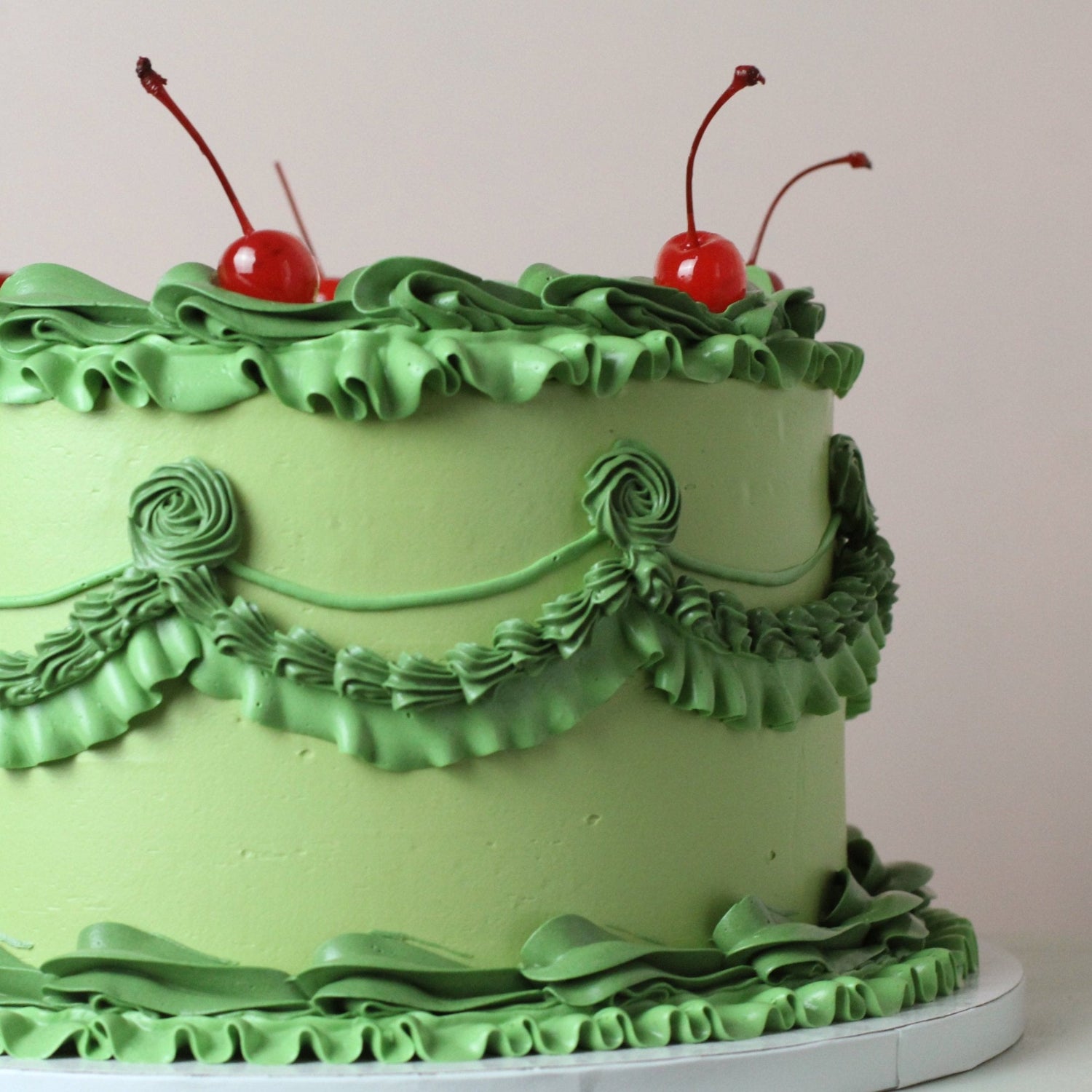 Vintage style frill cake, decorated with green frills and red cherries. Hand-made in our kreuzberg studio - delivered in Berlin