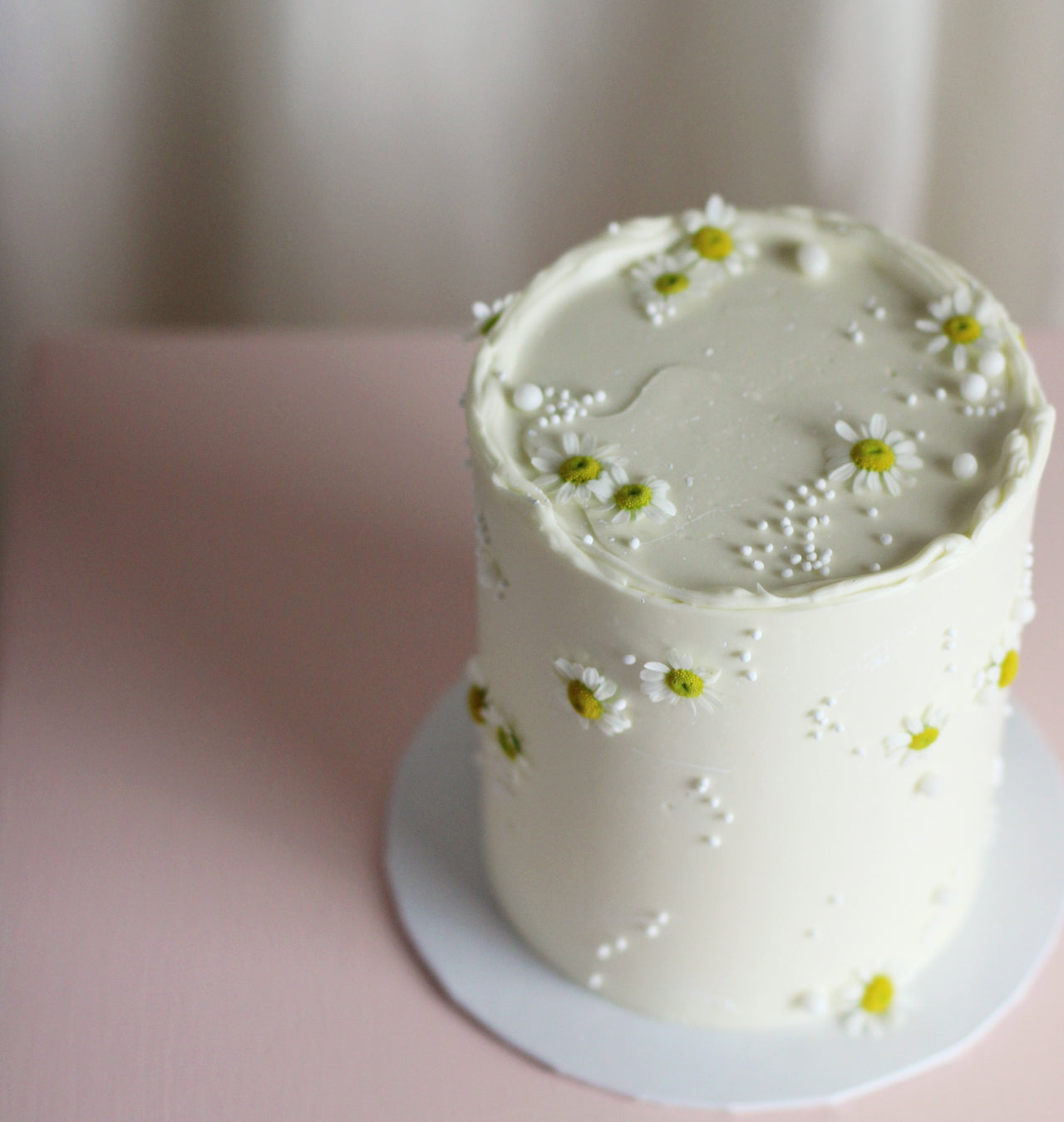 Fresh daisies on a white cake base - classic as a Gender reveal cake