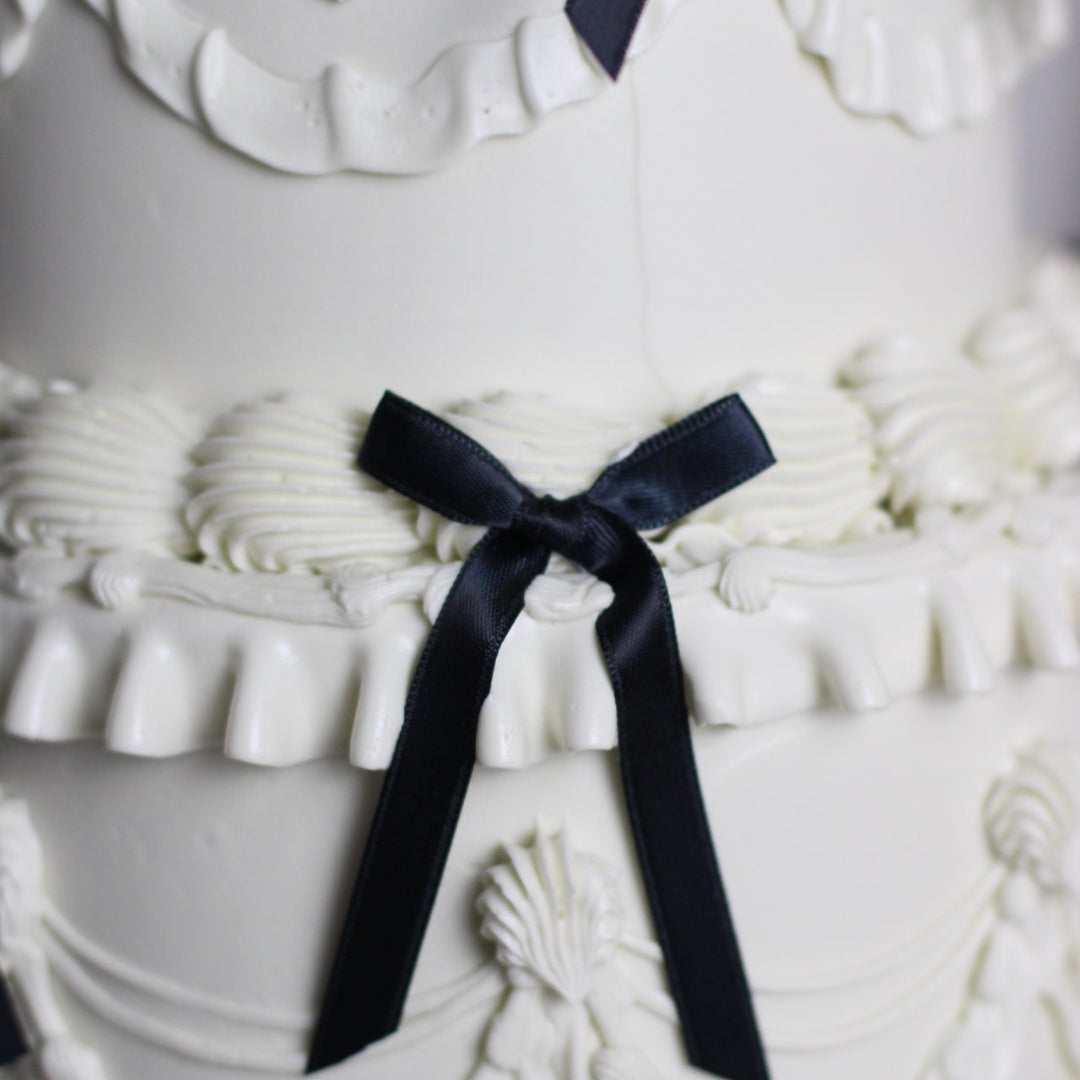 All white frill cake with black silk bows.