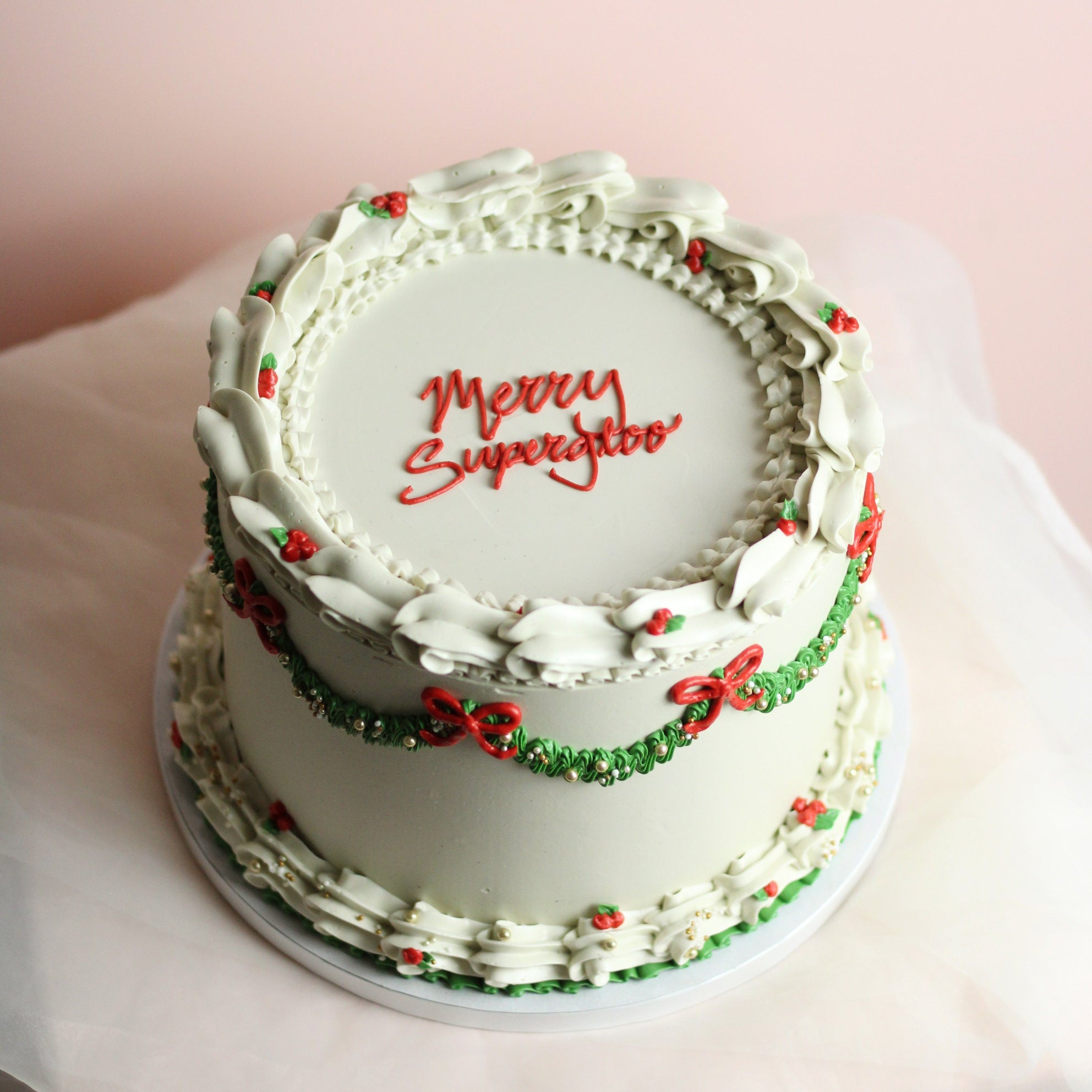 Festliche weiße Weihnachtstorte mit roten Schleifen und grünen Verzierungen – perfekt für jede Weihnachts- und Feiertagsfeier.
