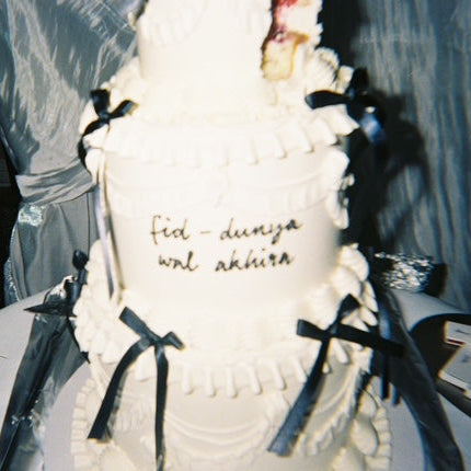 Chic wedding cake with white vintage buttercream frills and black silk bows.