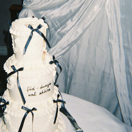 Chic wedding cake with white buttercream and black silk bows.
