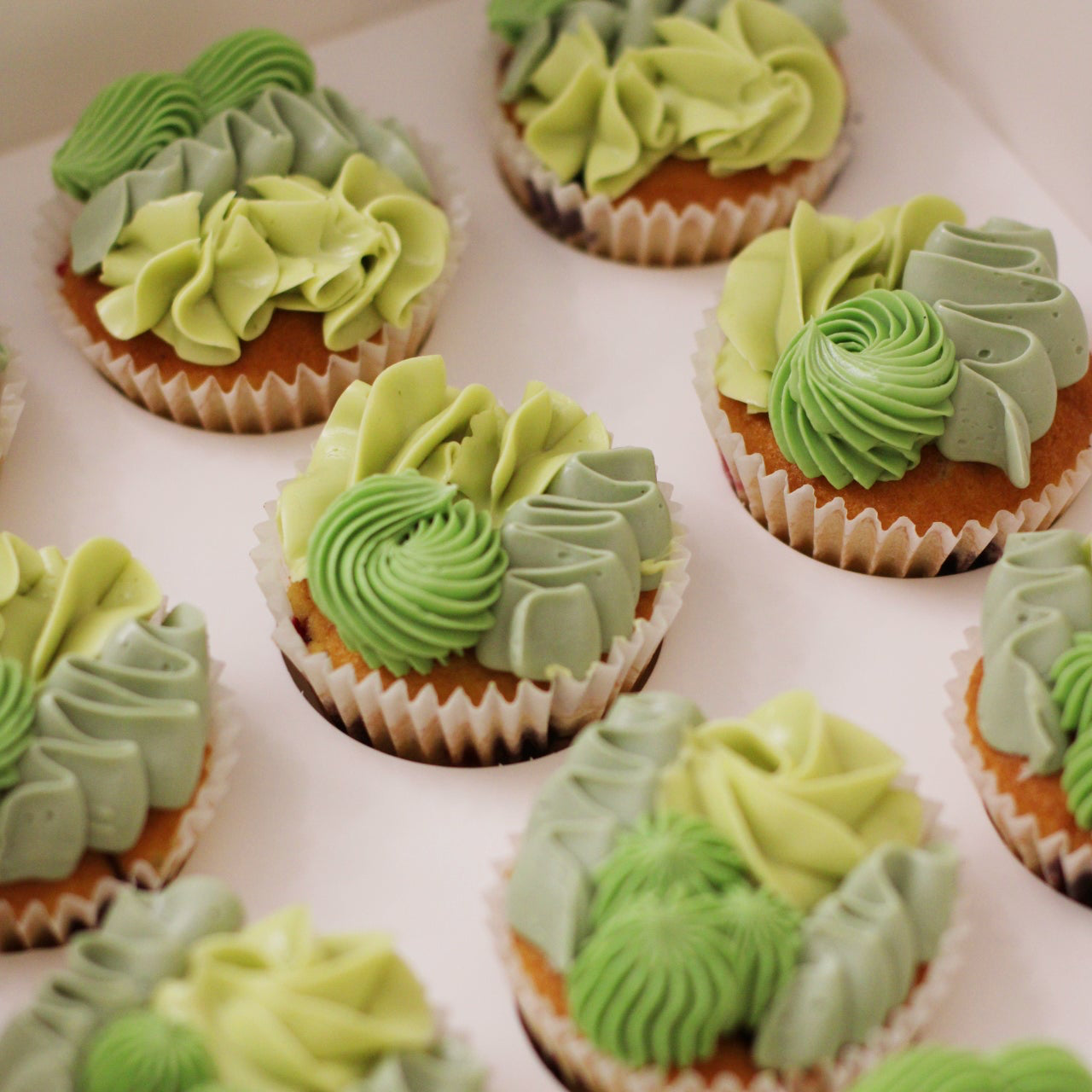 Mixed piping cupcakes in shades of green