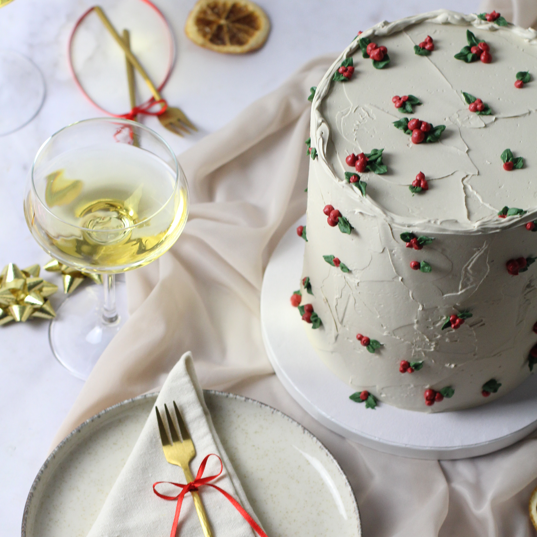 Holiday cake with textured buttercream, adorned with hand-painted hollies.