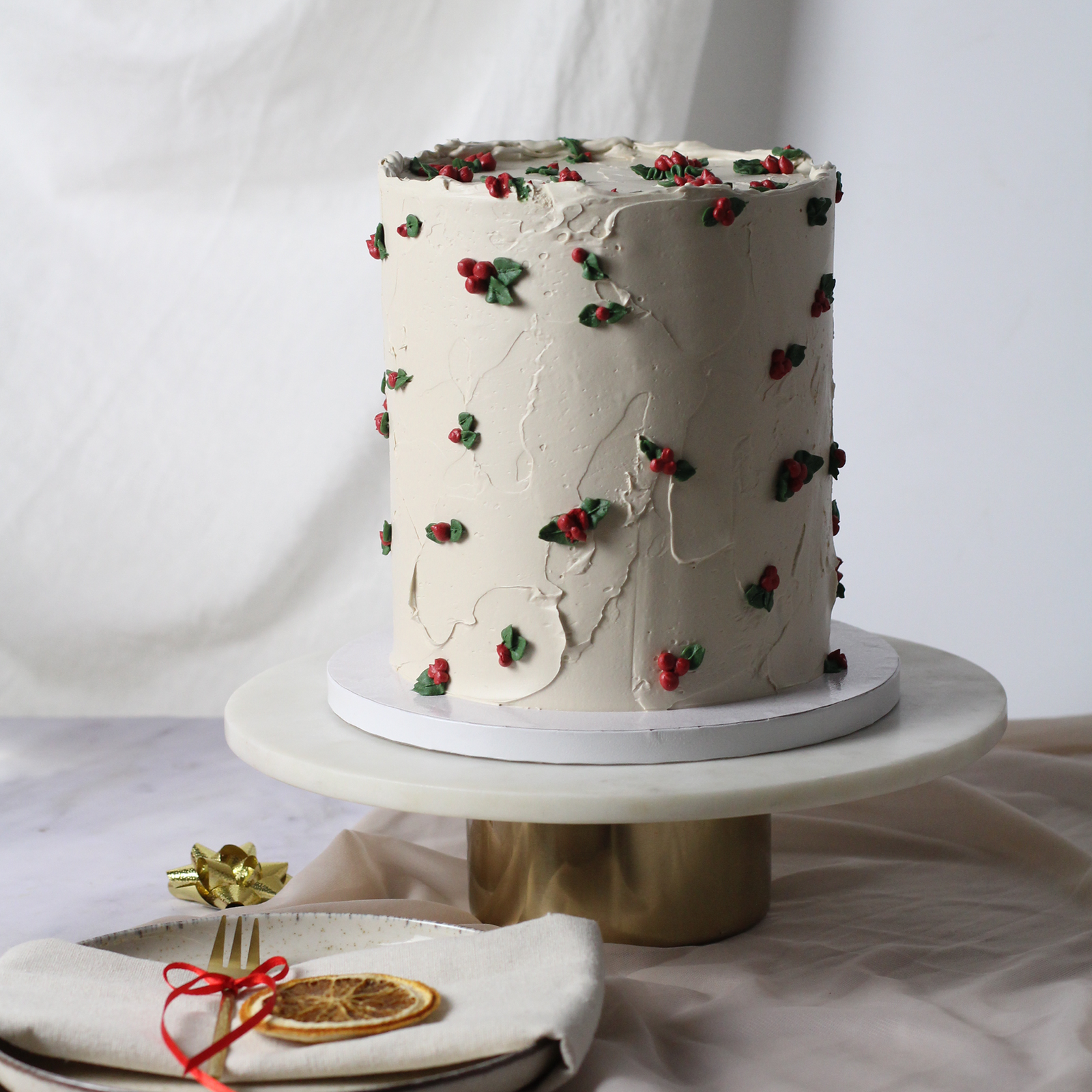Holiday cake with textured buttercream, adorned with hollies.