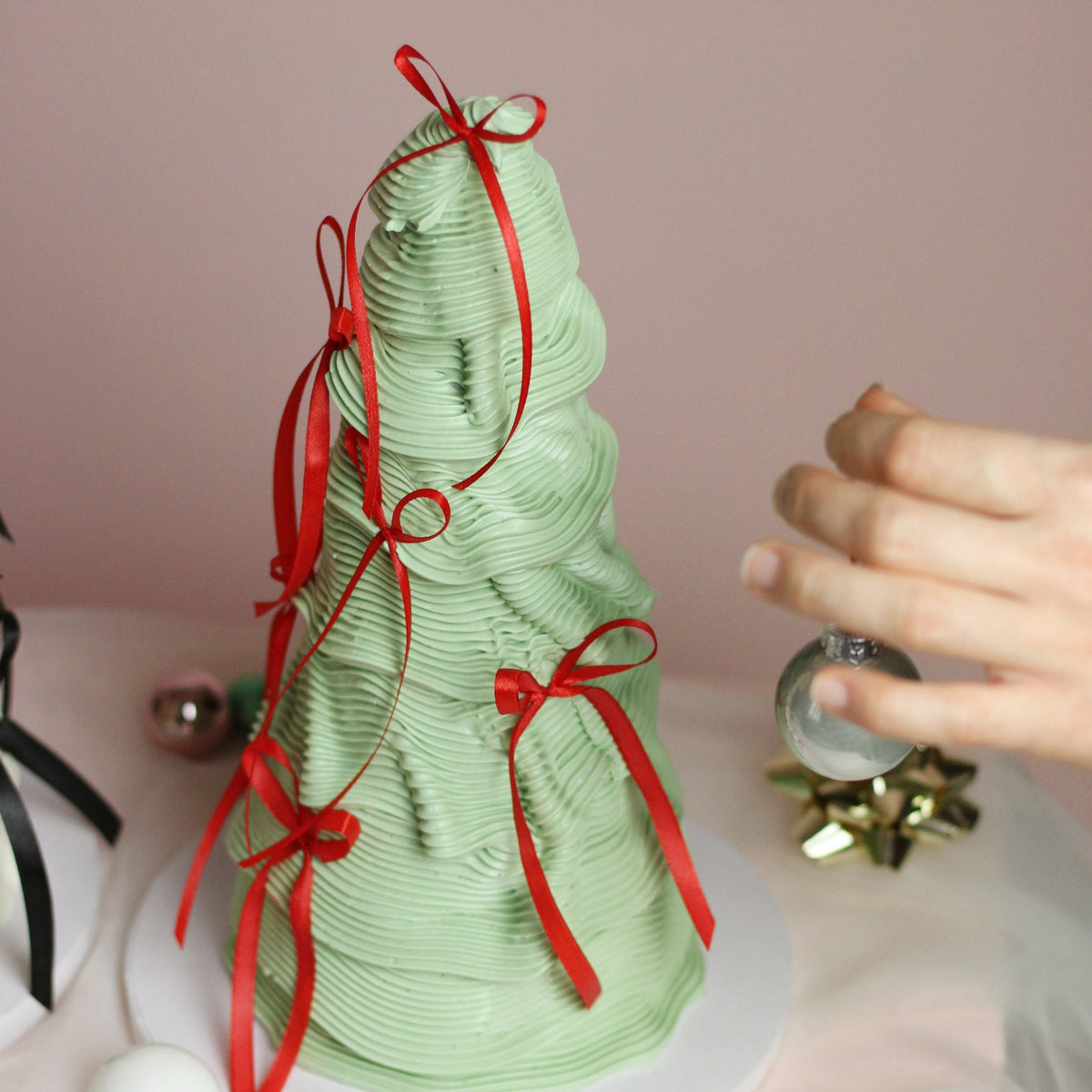 Weihnachtlicher Tannenbaum-Kuchen aus Buttercreme - stilvoll, festlich und mit Seidenschleifen veredelt.