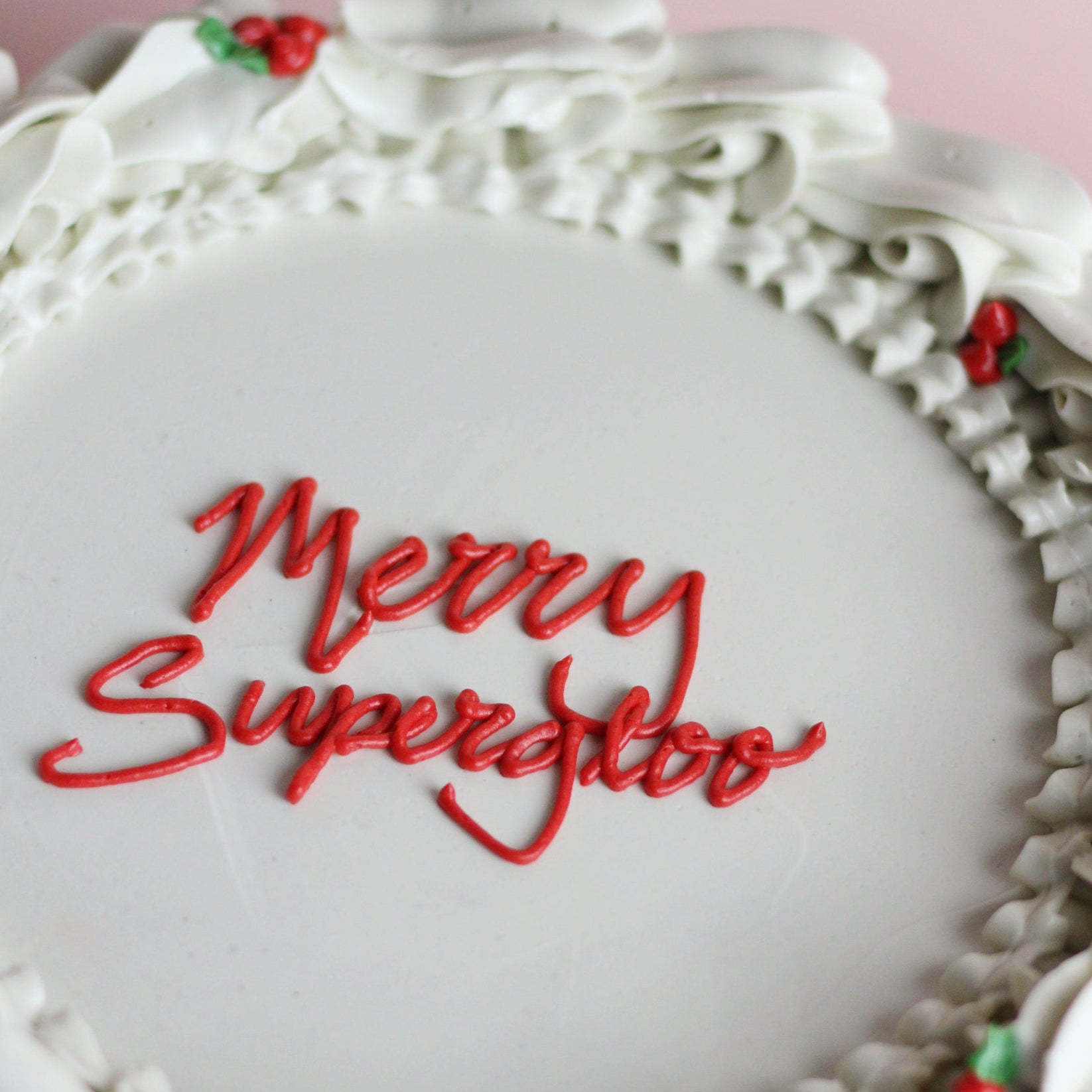 Festliche weiße Weihnachtstorte mit roten Schleifen und grünen Verzierungen – perfekt für jede Weihnachts- und Feiertagsfeier.
