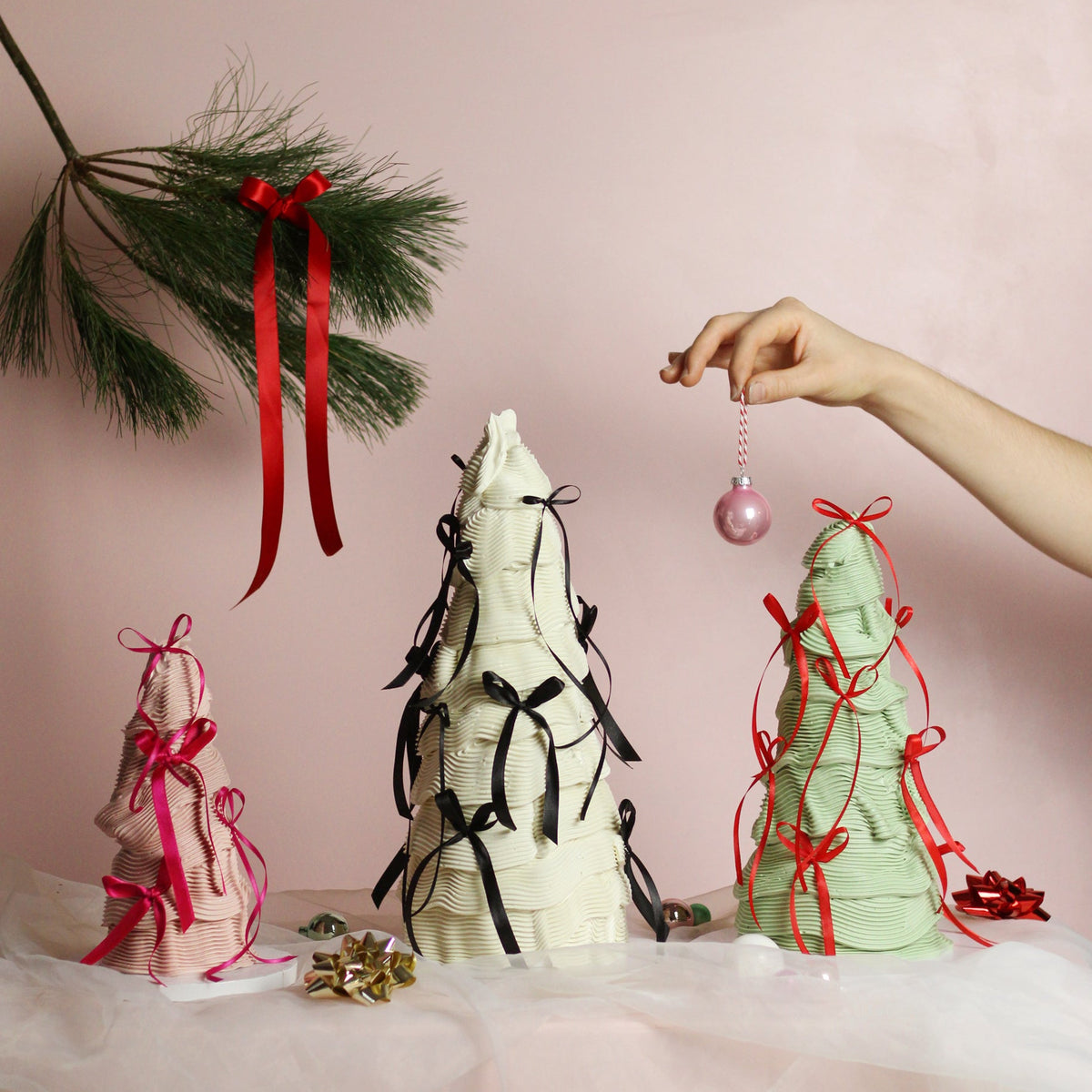 Festive tree-shaped buttercream cakes decorated with elegant piping and silk bows - the perfect Christmas centerpiece.
