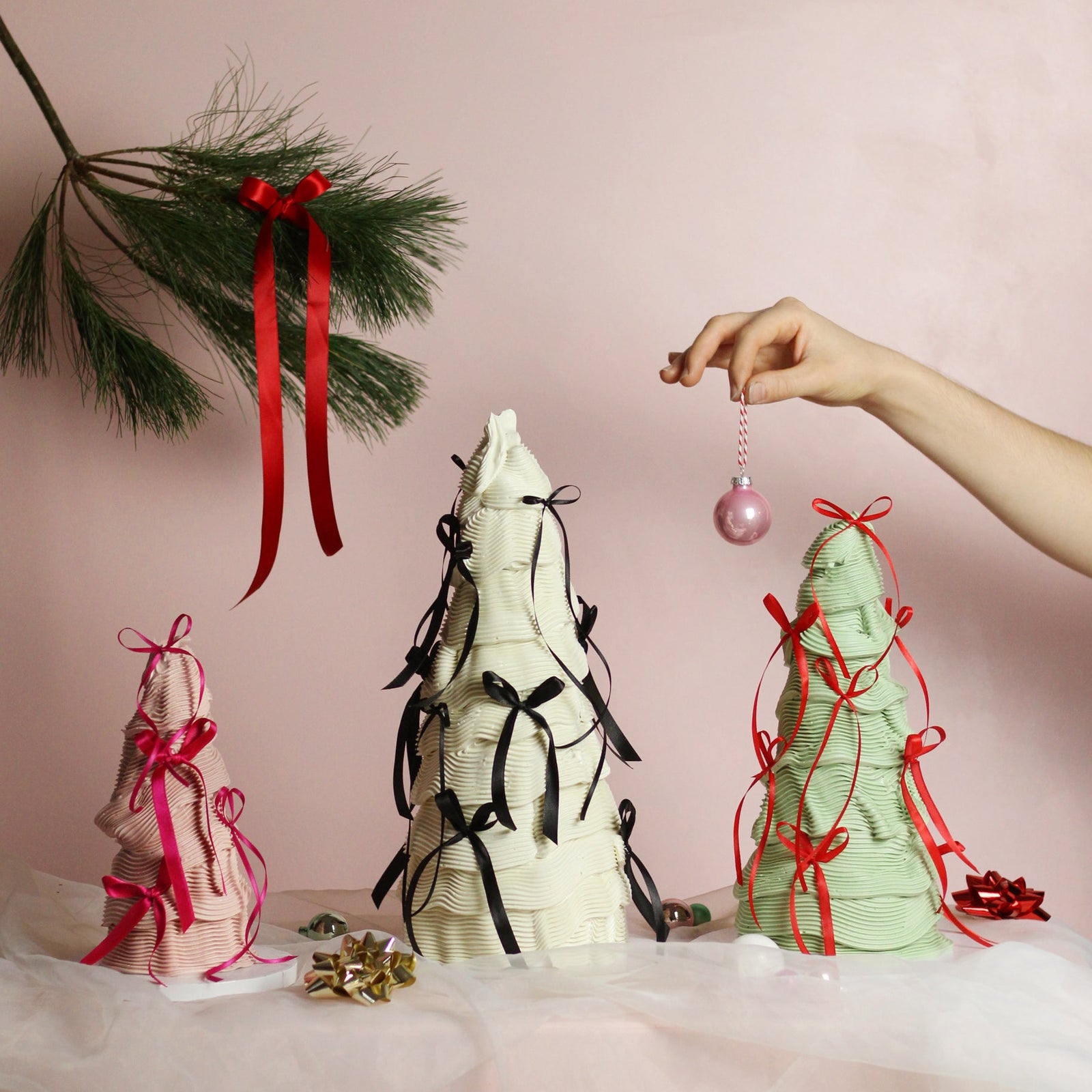 Festive tree-shaped buttercream cakes decorated with elegant piping and silk bows - the perfect Christmas centerpiece.
