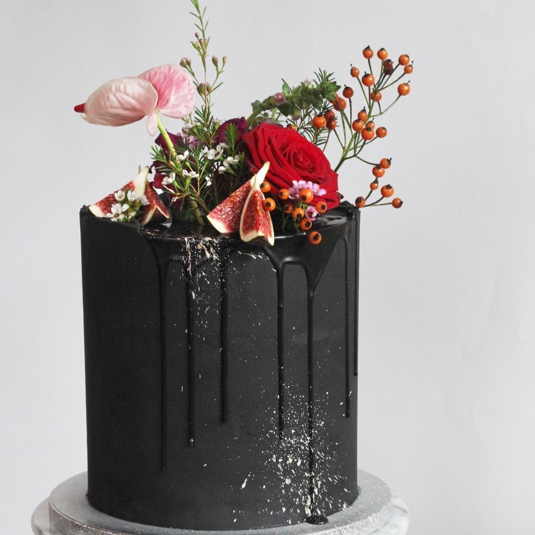 Our signature Bold Beauty with black on black icing and a bold headpiece of fresh flowers.