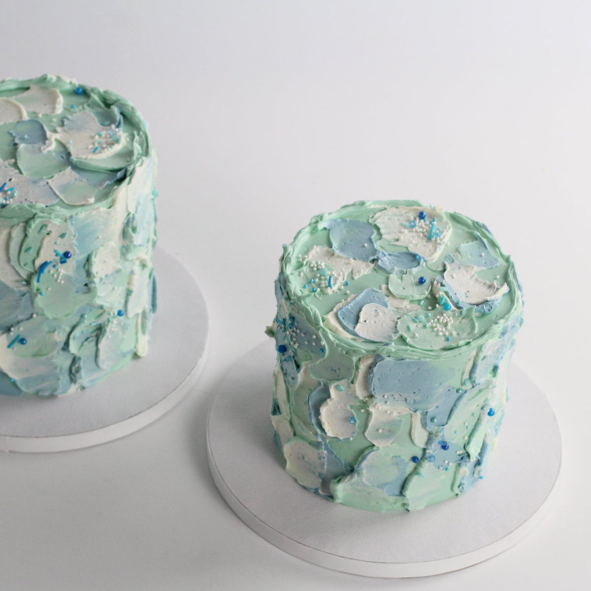 Our signature Cloud Cake with blue &amp; mint fluffy icing and a dash of sprinkles.