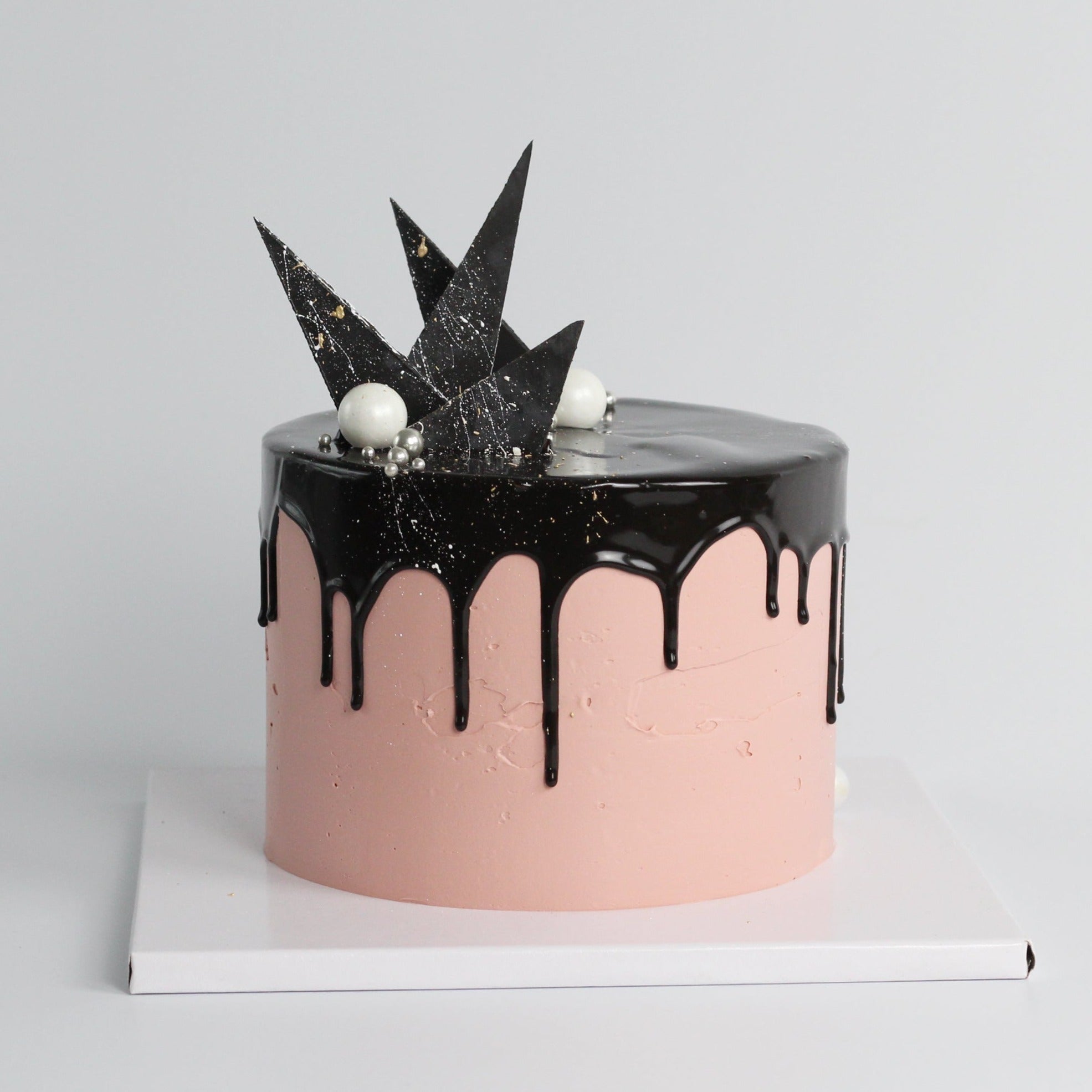 The Concrete Cake - dipped in black drip icing, with geometric chocolate forms.