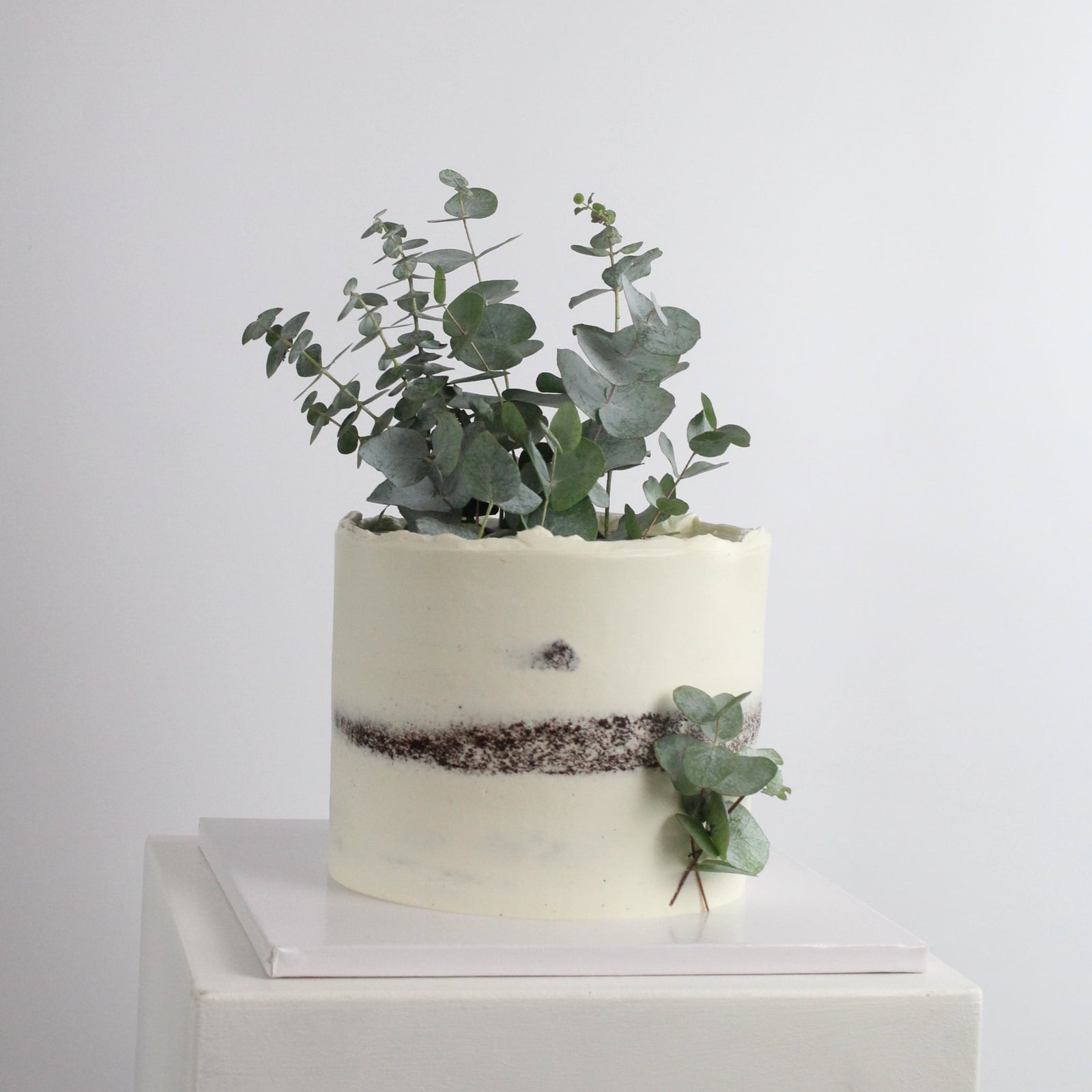 Forest Fairy Cake - Our signature semi-naked style decorated with Eucalyptus leaves. Made at our bakery in Kreuzberg - Delivered in Berlin.