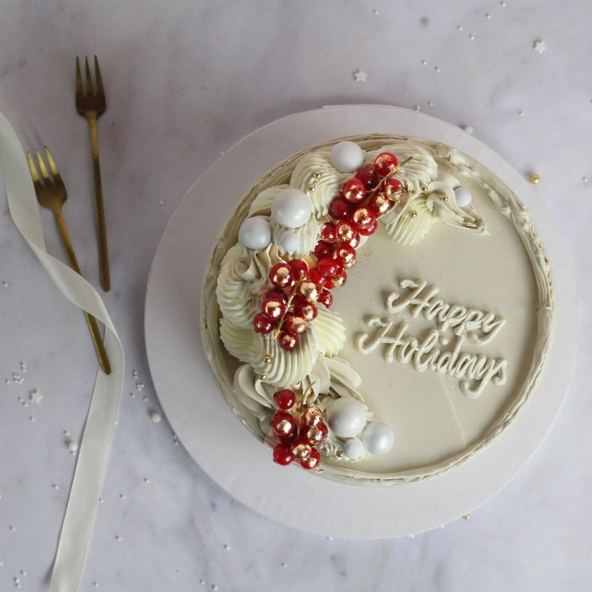 Festive All-white cake decorated with fresh cranberries and gold hand-painted gold details, perfect for elegant celebrations, festive dessert tables, and special occasions.