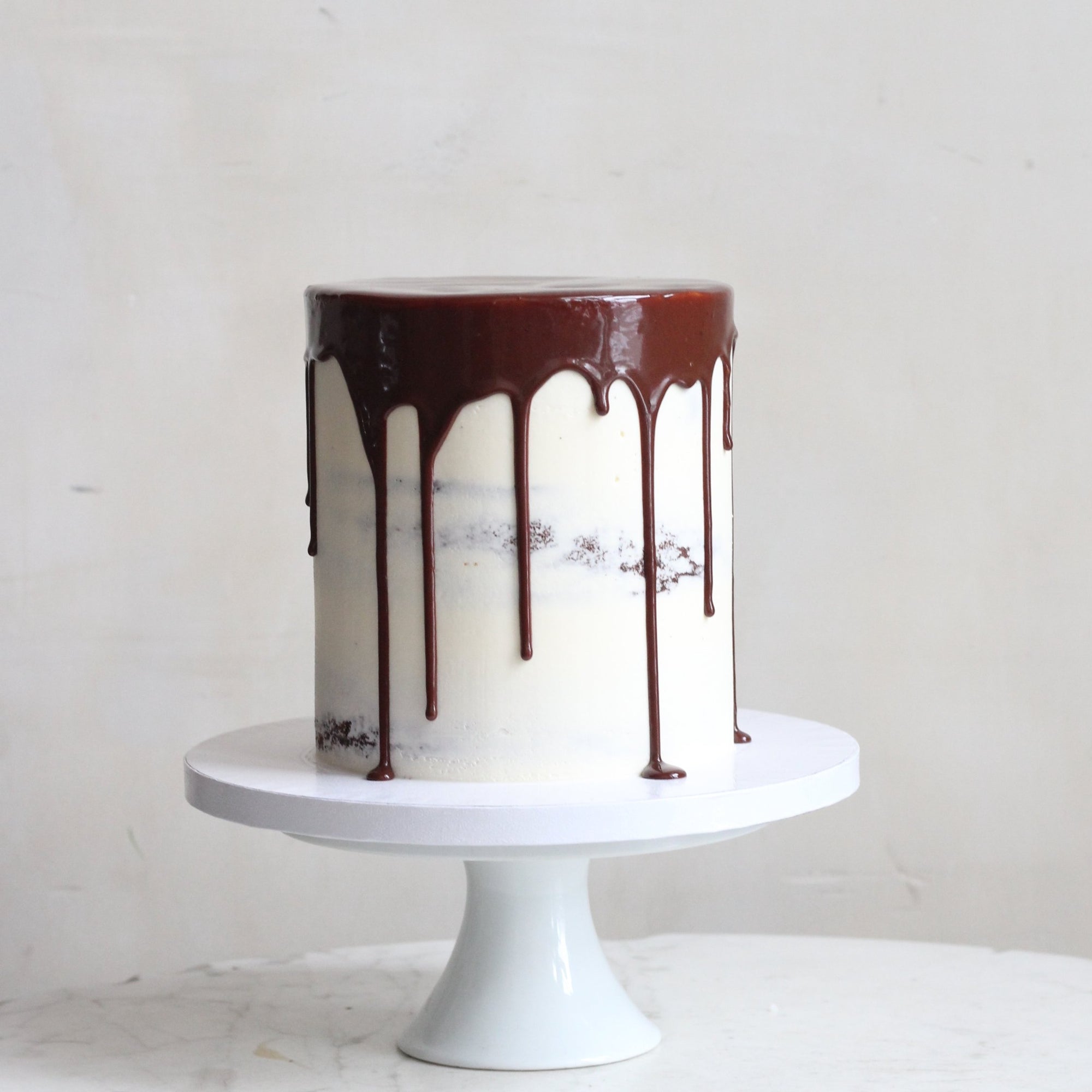 A semi-naked cake dipped into melty hot chocolate.