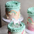Our Rainbow Cake with peach & mint ombre icing, 3D rainbows, creamy ruffles and unicorn topper!