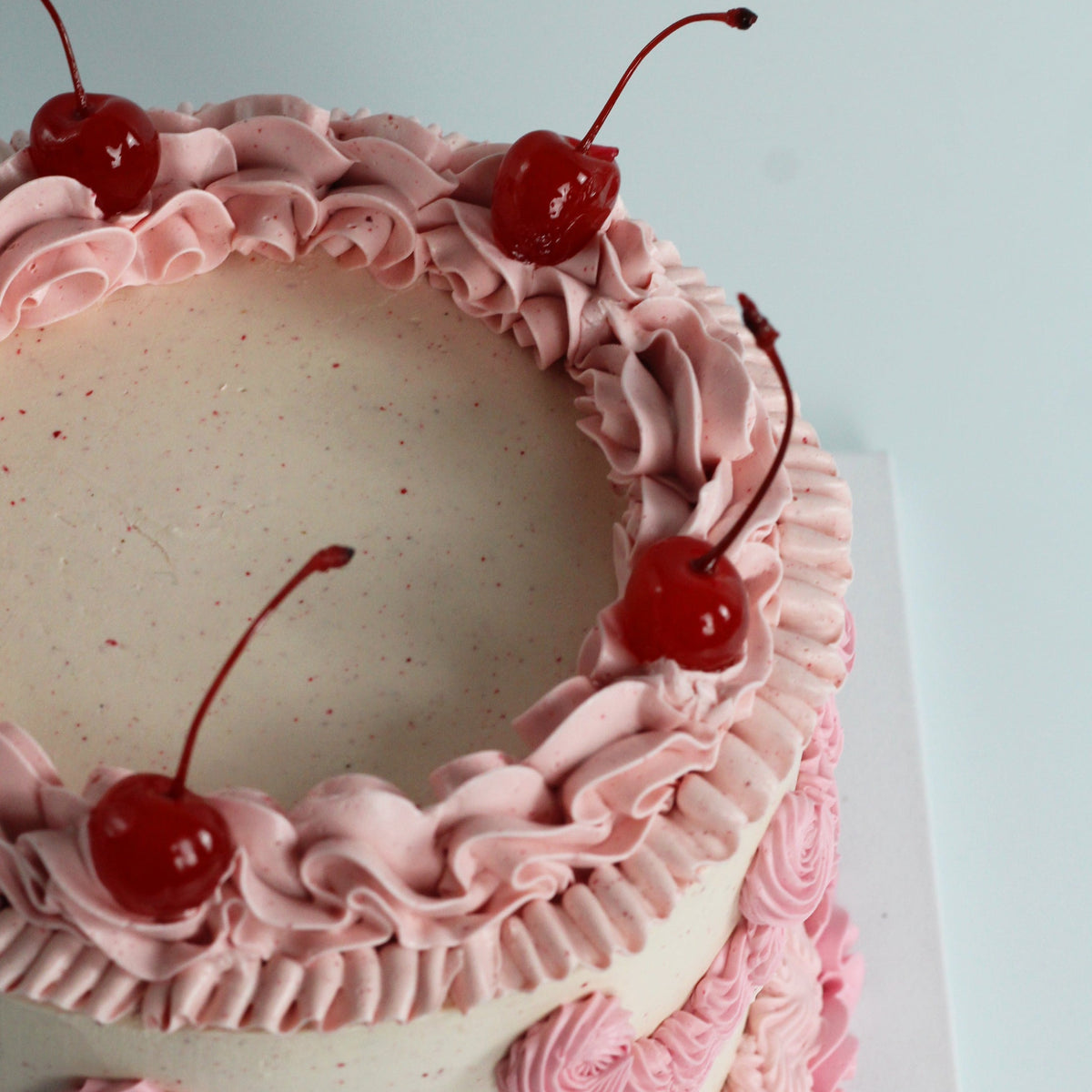 Es ist Party Zeit! Buttercreme-Zuckerguss mit Rüschen im Vintage-Stil mit einer Paspelbotschaft und Kirschen darauf – der perfekte Kuchen.